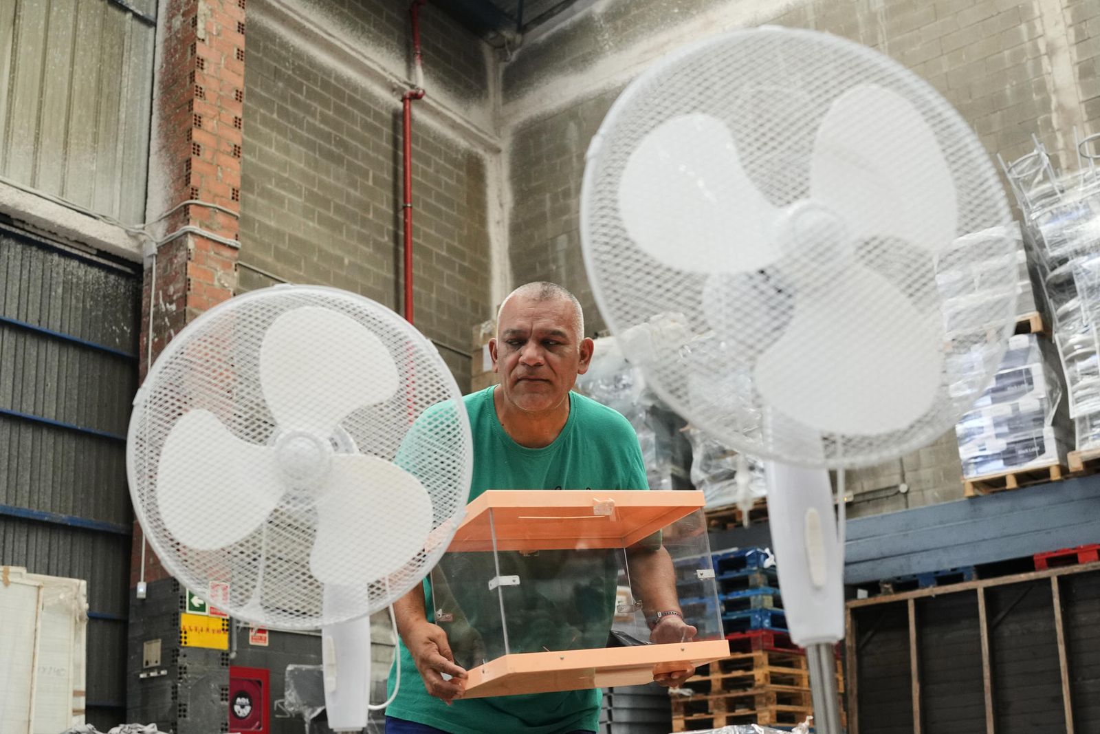 Un operario traslada urnas y ventiladores