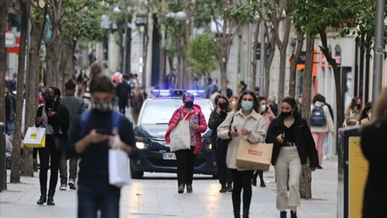 Personas caminan por una calle comercial