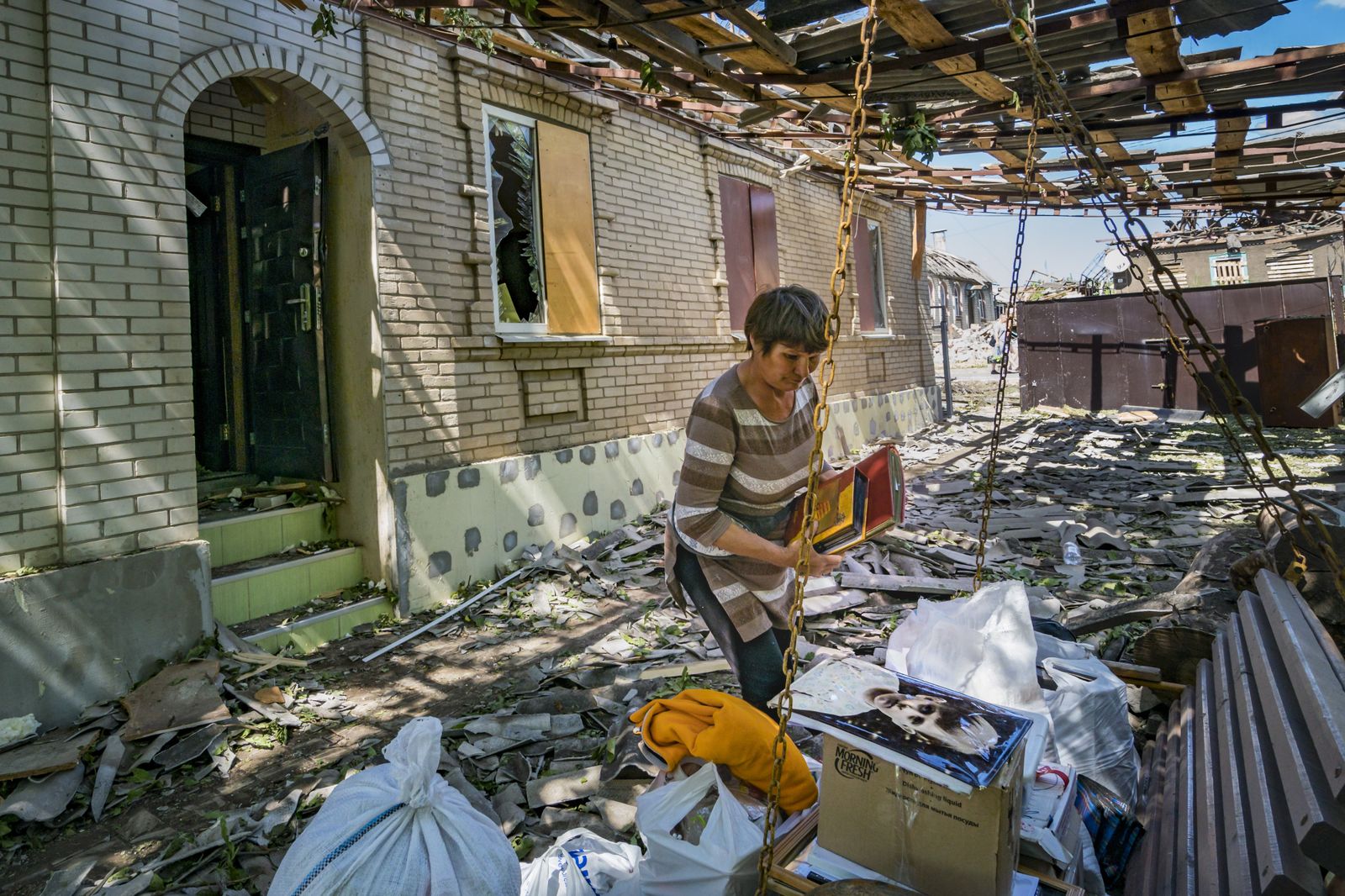 Una mujer recoge sus pertenencias en su casa, destruida por un misil ruso en Druzhkivka, Donbás