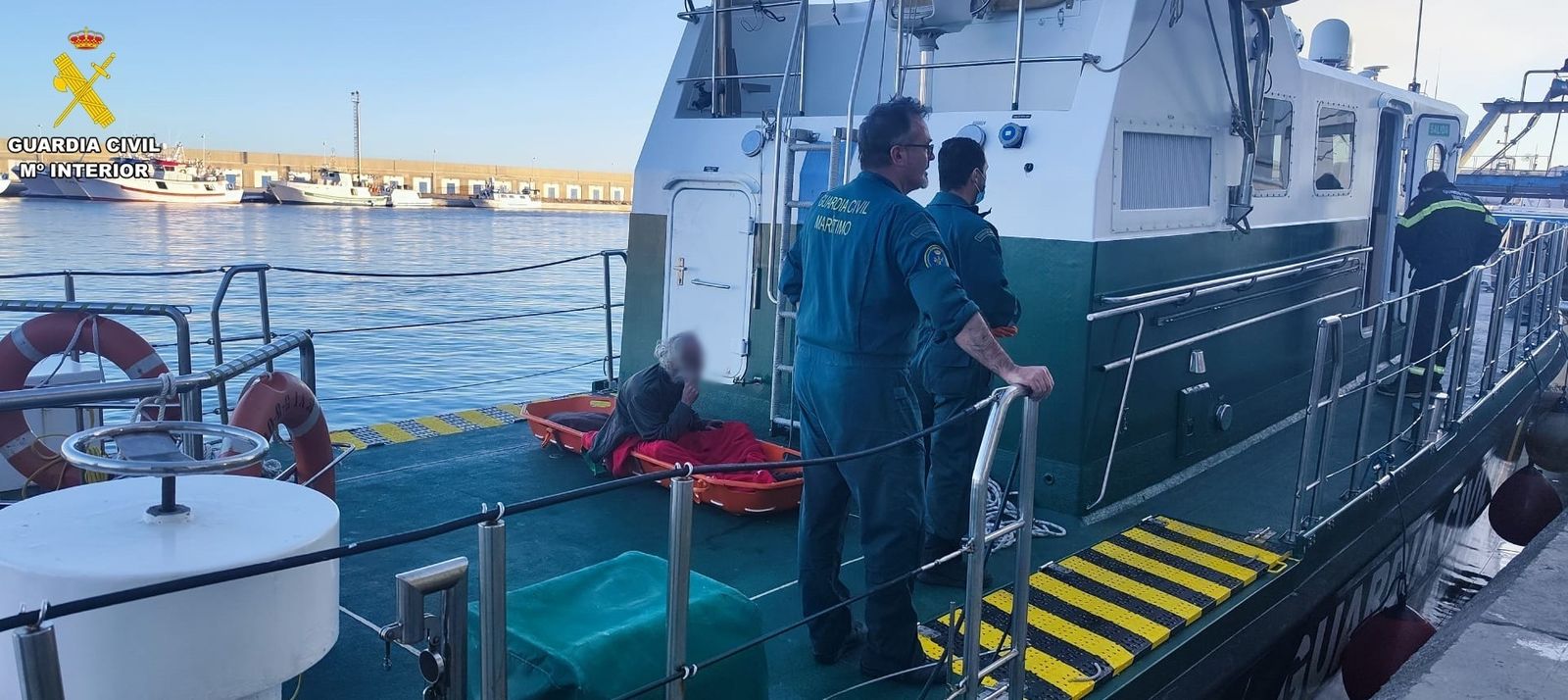 Agentes del Servicio Marítimo de la Guardia Civil con la persona rescatada aún a bordo