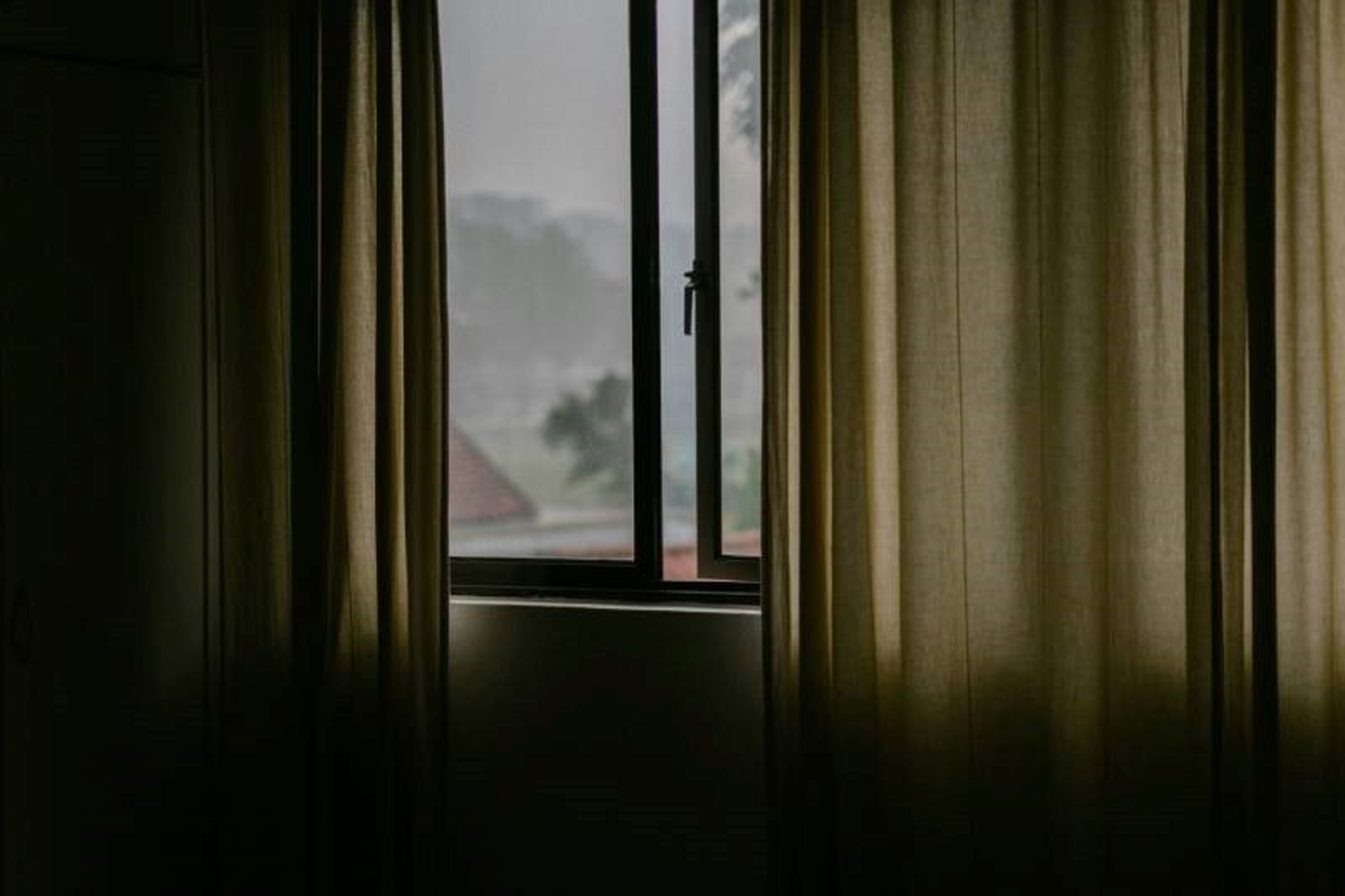 Ventana entreabierta en la habitación de una casa
