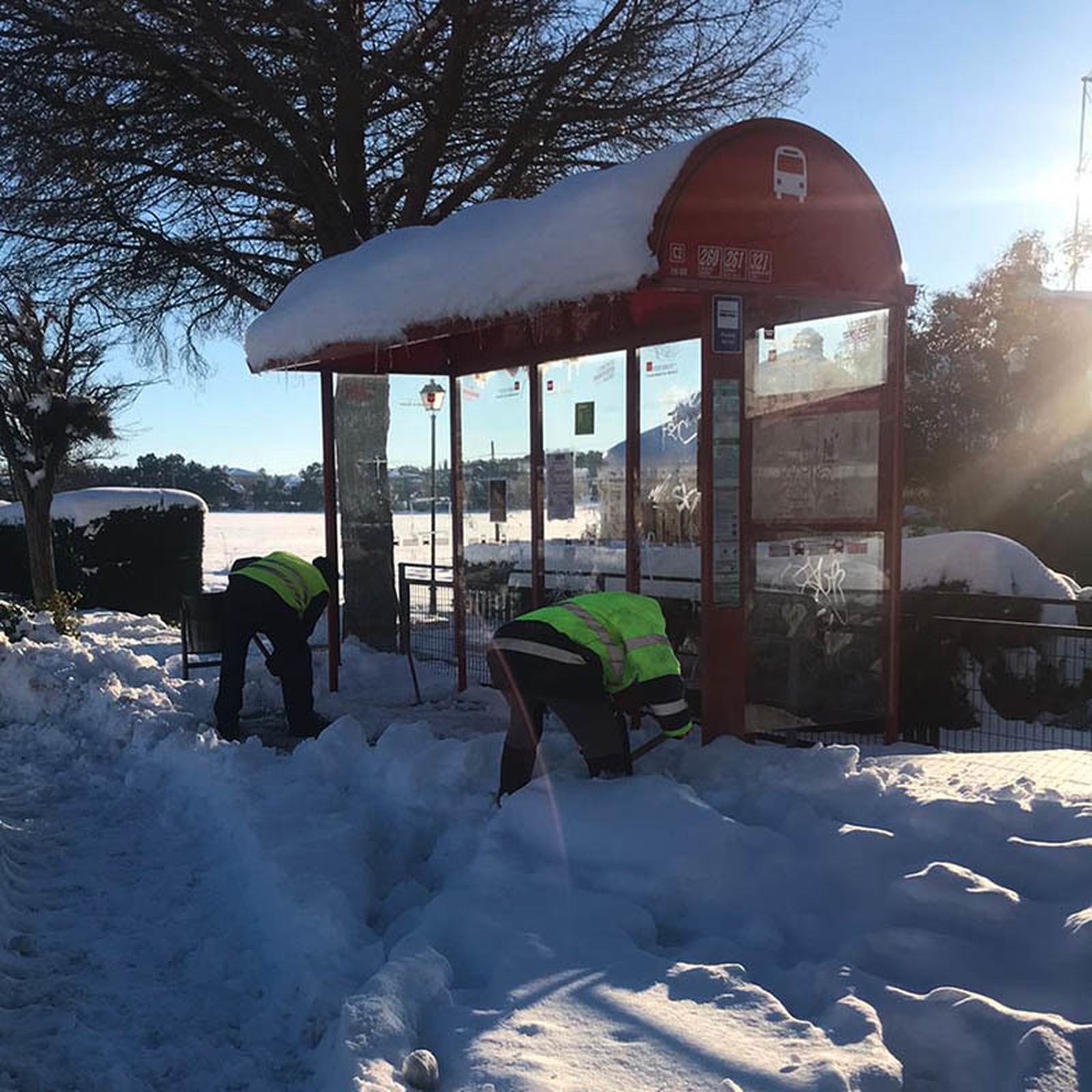Trabajadores municipales despejan de nieve una marquesina en Nuevo Baztán