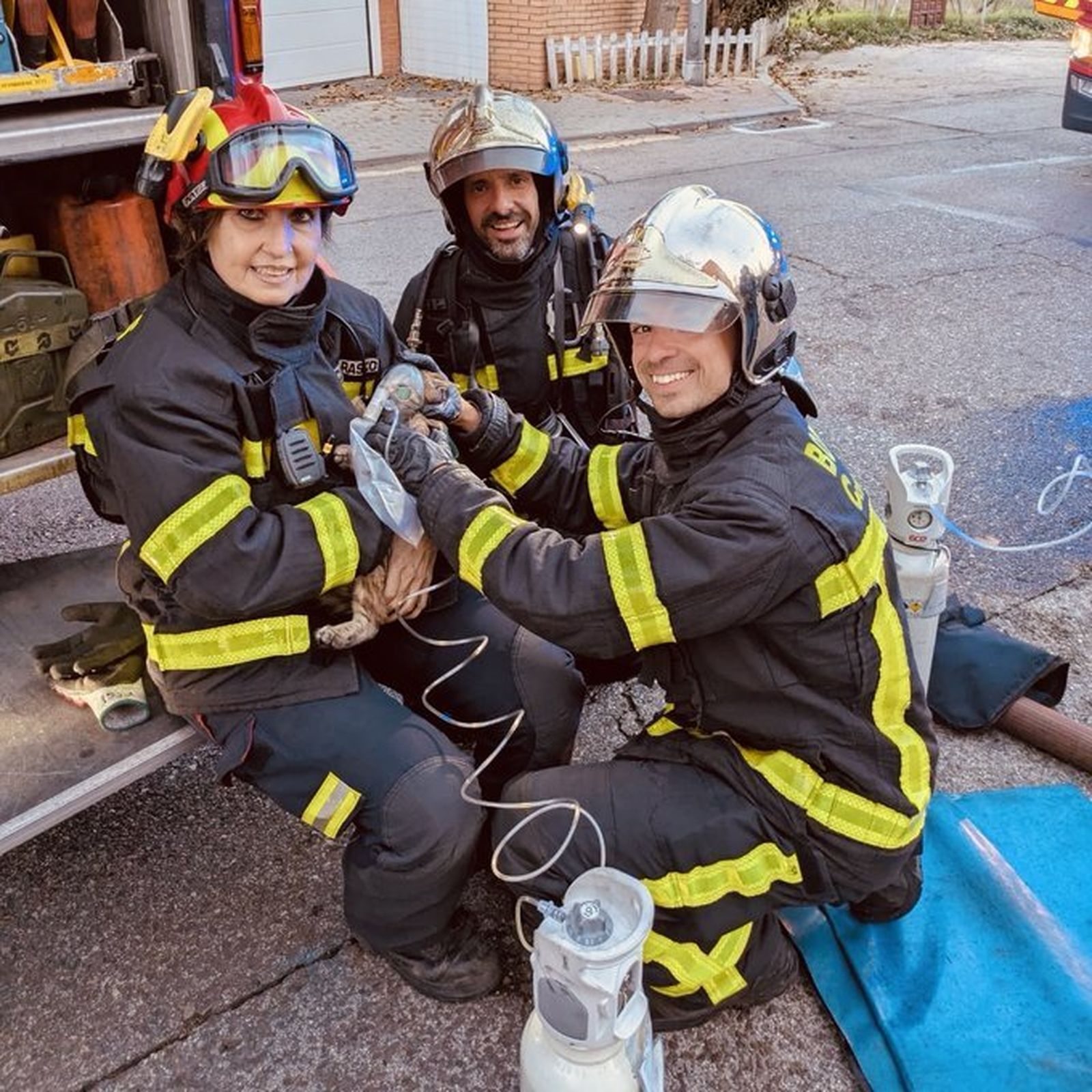 Bomberos suministrando oxígeno a un gato tras rescatarlo de un incendio en Móstoles