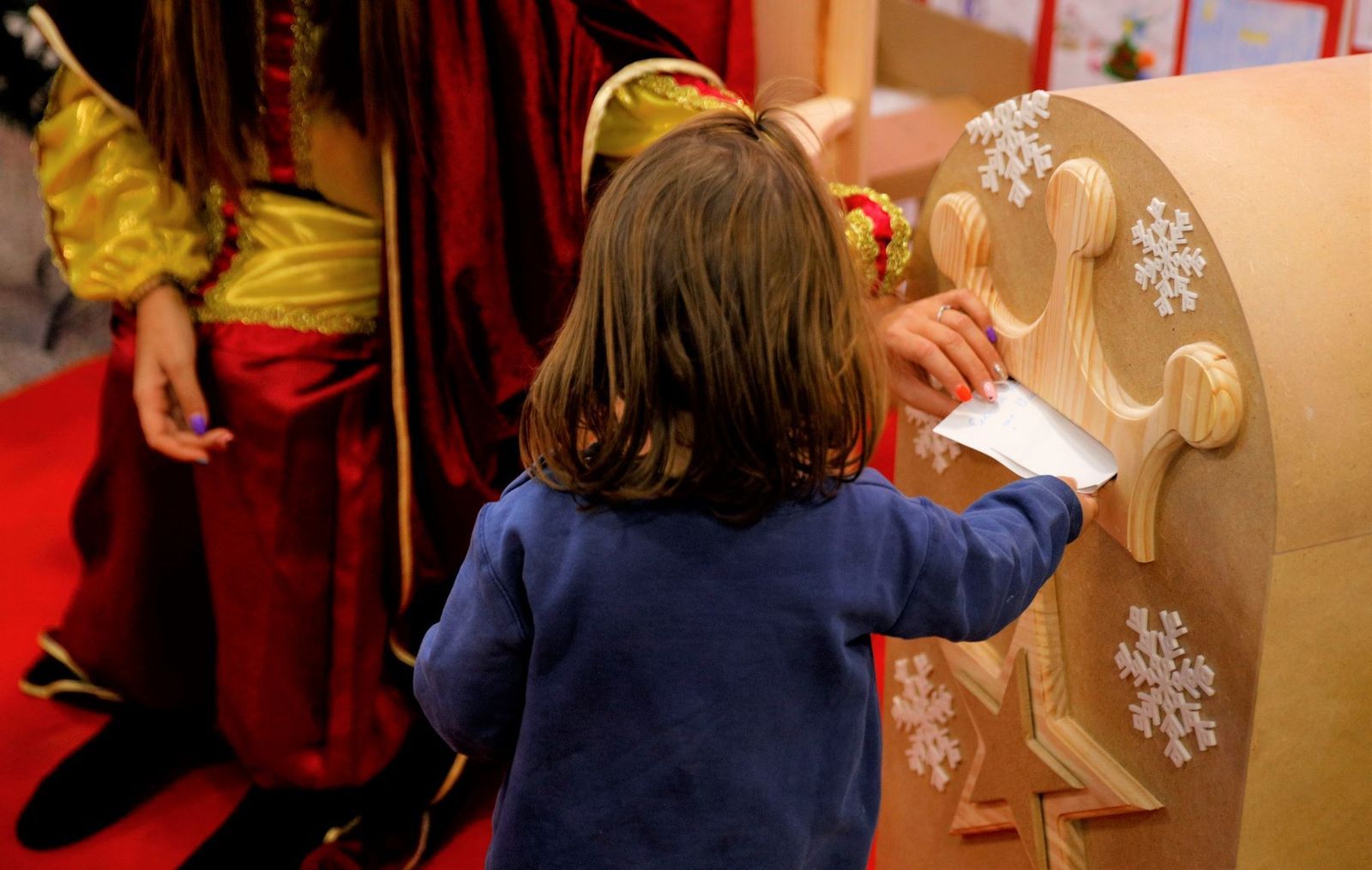 Una niña introduce su carta en el buzón de los Reyes Magos