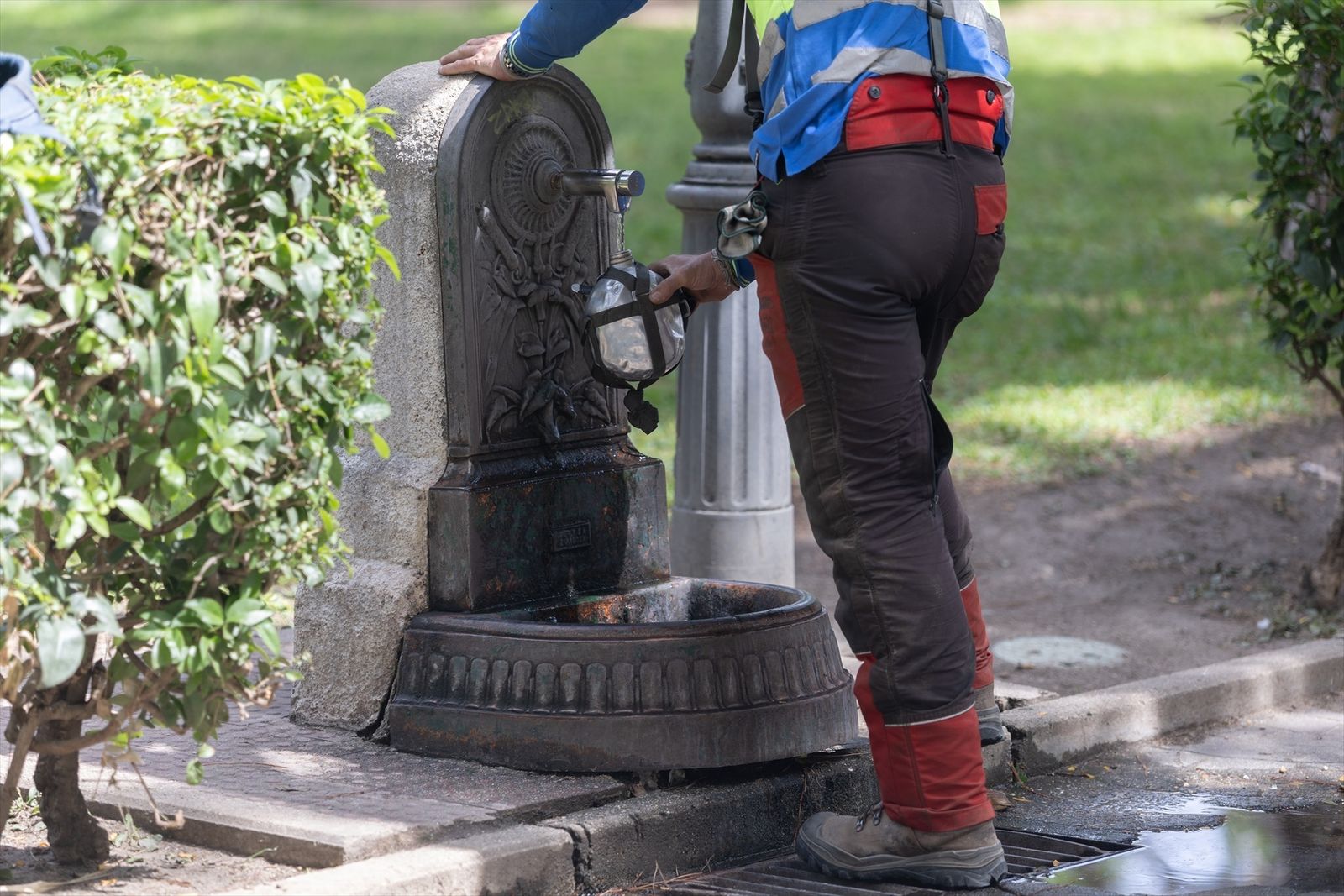 Hombre rellenando una botella en una fuente