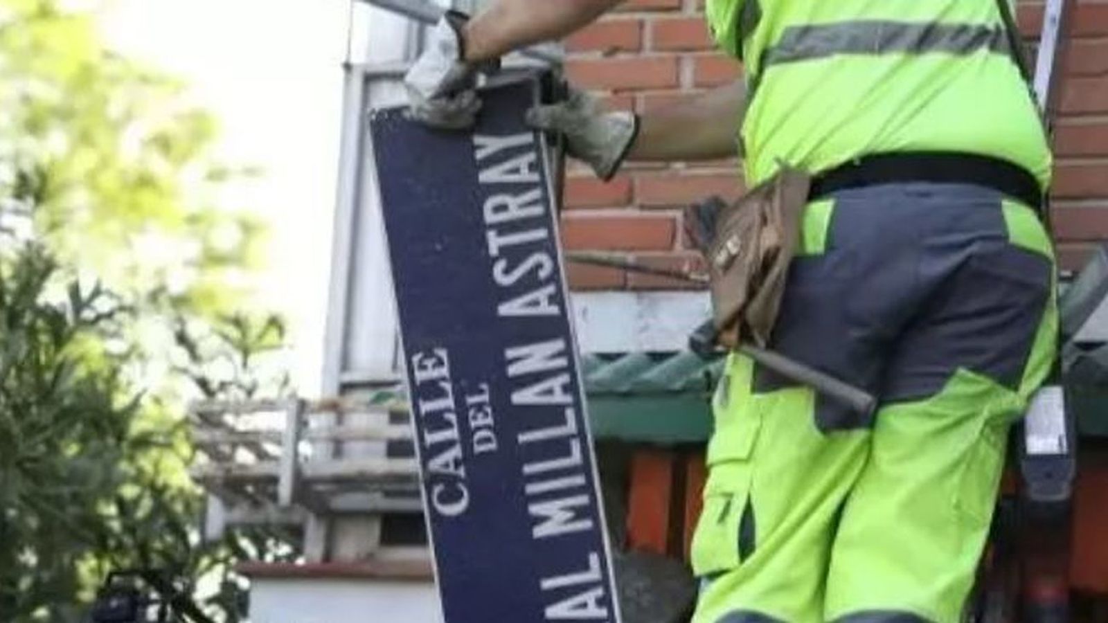 Un operario con la placa de la calle del general Millán Astray