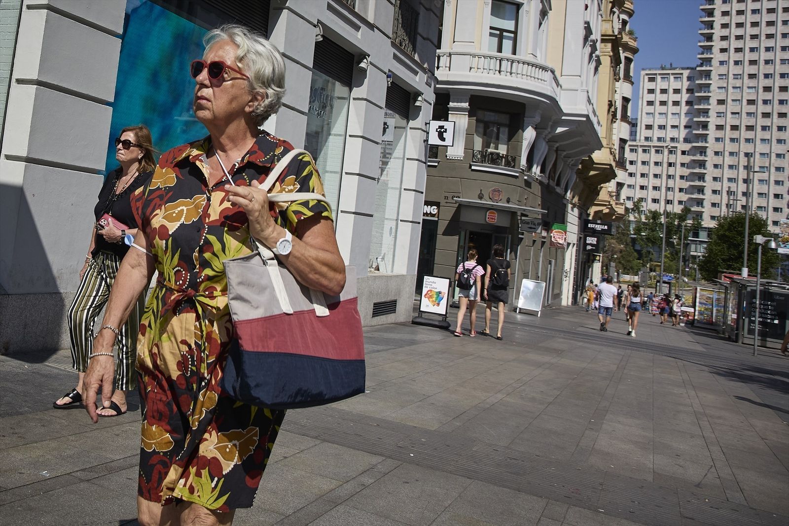Mujer pasea por la Gran Vía en pleno verano