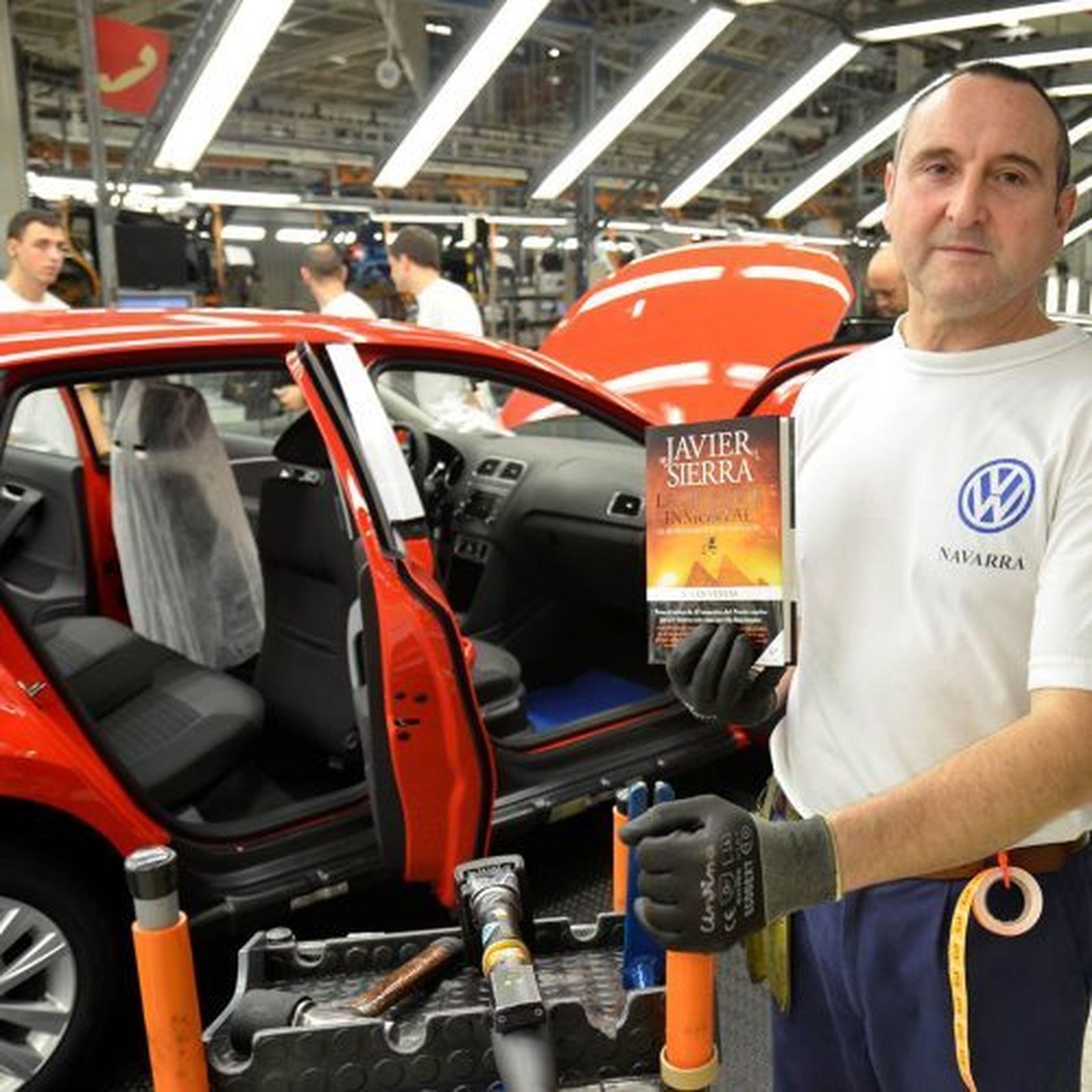 Un trabajador de Volkswagen sostiene uno de los ejemplares junto a la cadena de montaje