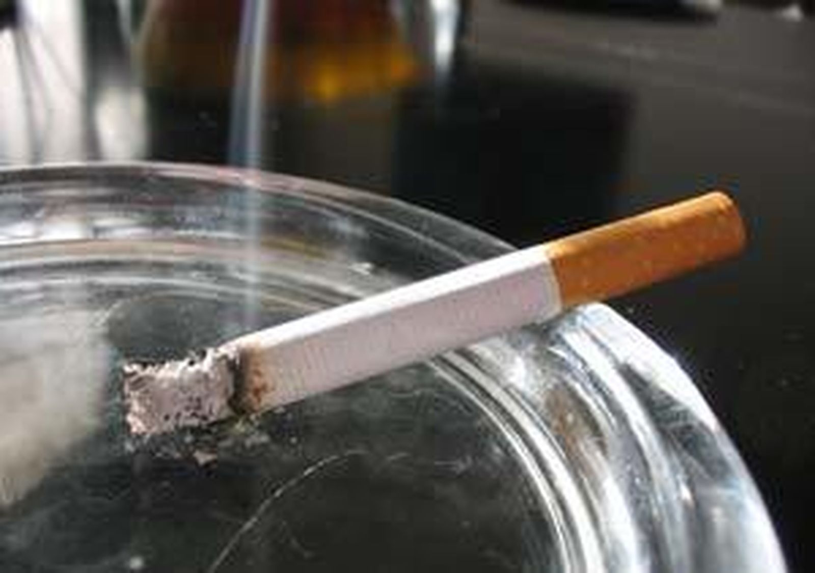 Un cigarrillo consumiéndose en un cenicero
