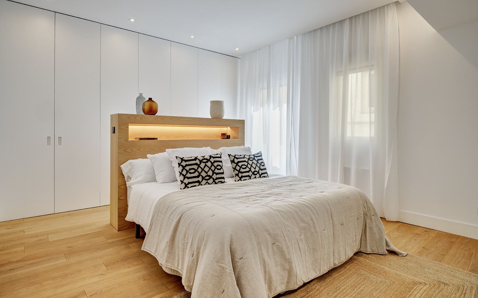 Y tiene un dormitorio principal cuya cama es una 'isla' que esconde detrás un enorme zapatero.