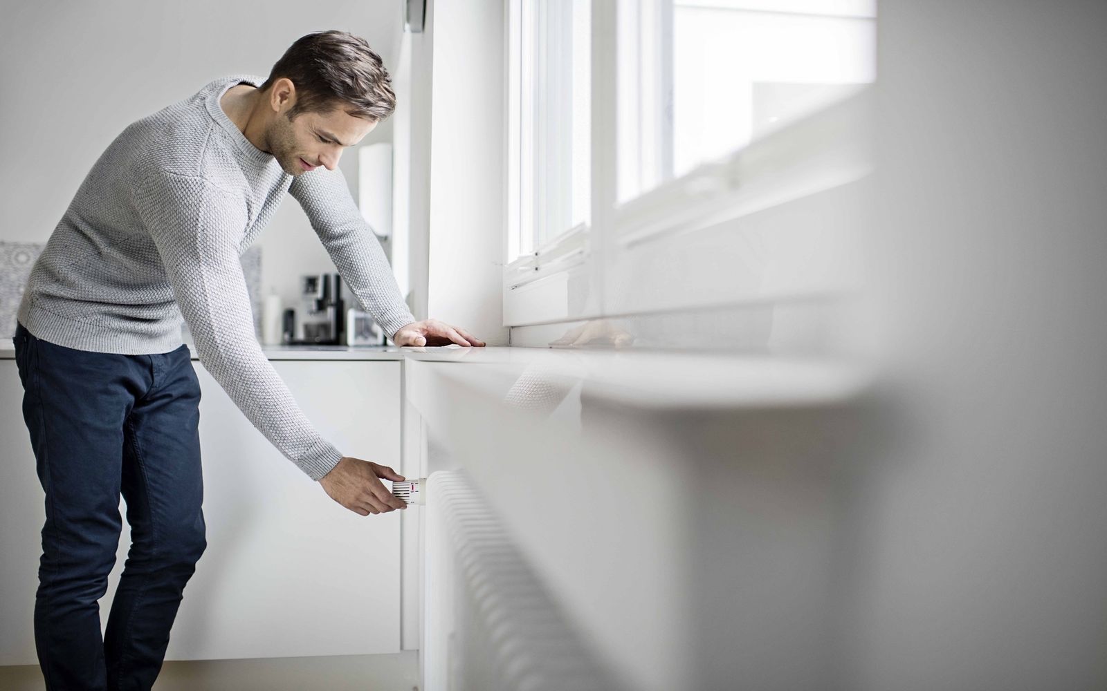 Un hombre ajustando la calefacción