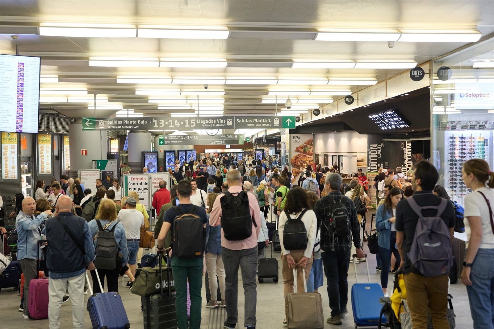 Viajeros con maletas recorren los pasillos de una de las instalaciones de la estación Almudena Grandes-Atocha Cercanías