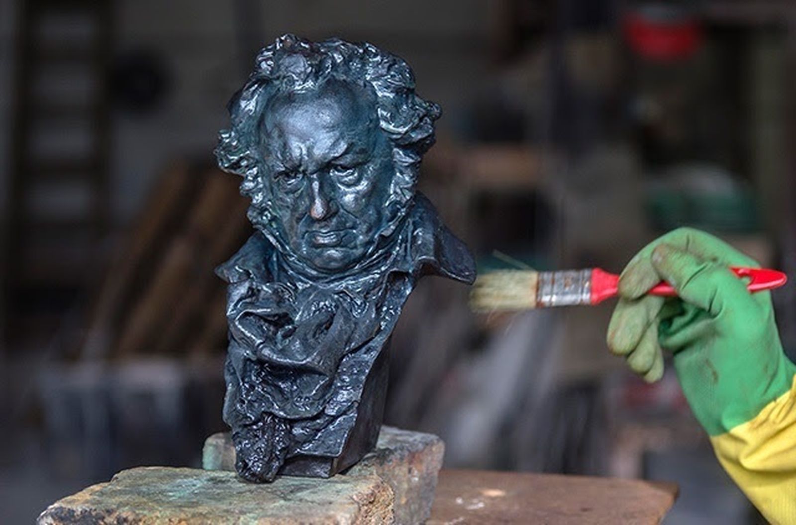 Un técnico limpia uno de los Los 'cabezones' de los Premios Goya