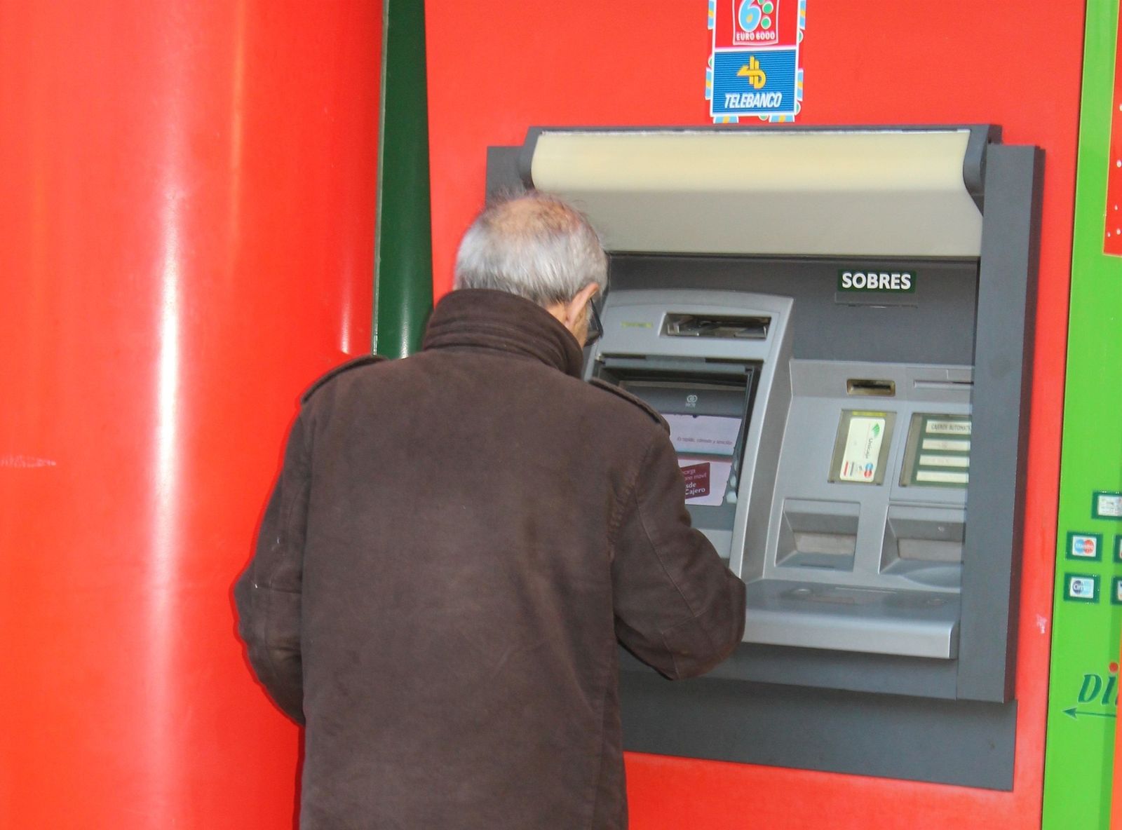 Persona mayor sacando dinero de un cajero