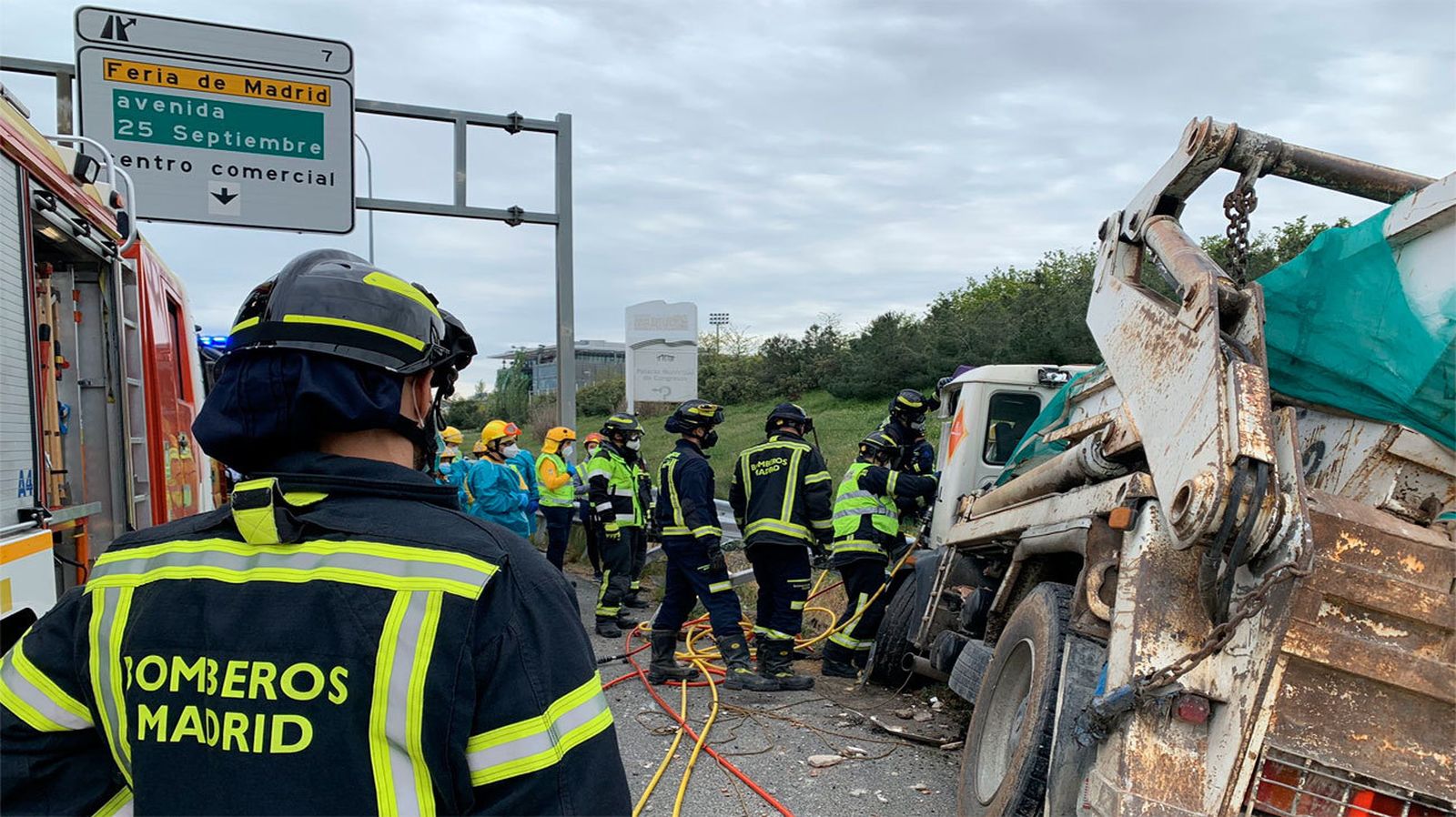 Los bomberos tratan de rescatar al camionero atrapado tras un accidente en la M-40