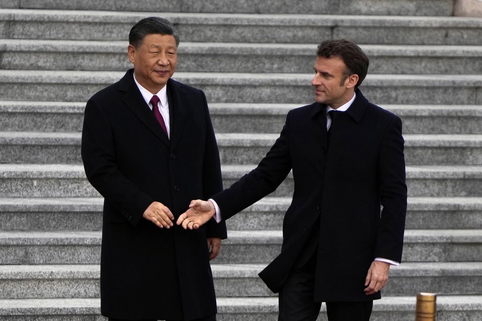 El presidente francés, Emmanuel Macron (derecha), le da la mano al presidente chino, Xi Jinping (izquierda), durante una ceremonia de bienvenida celebrada frente al Gran Salón del Pueblo en Beijing, China, el 6 de abril de 2023.