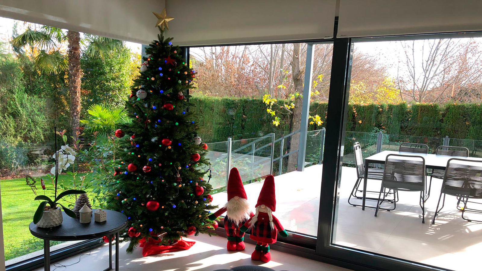 En esta vivienda combinan los colores rojos de la Navidad con el verde intenso del césped del jardín.