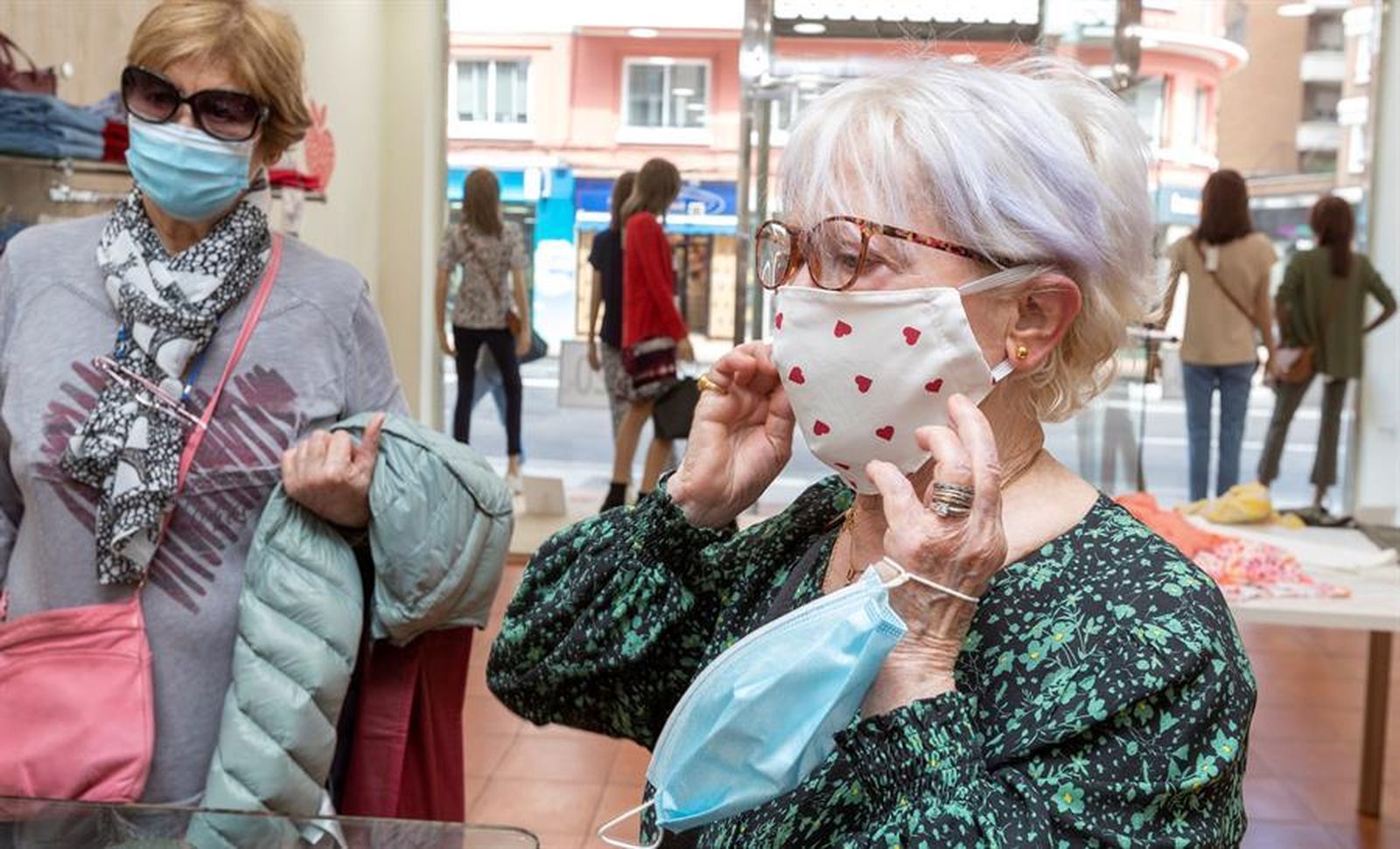 Varias mujeres con mascarilla, en una tienda