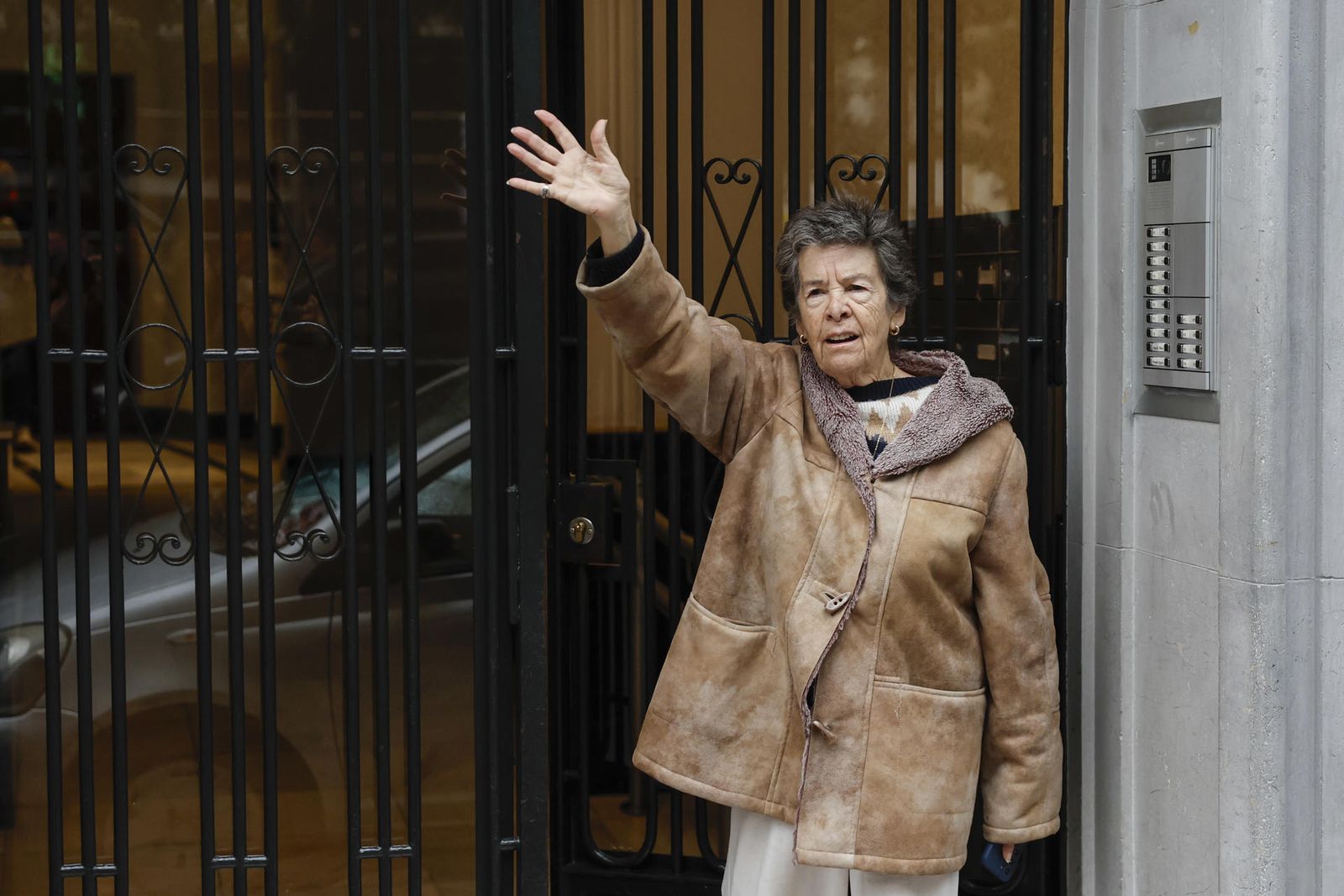 Maricarmen, de 87 años, amenazada de desahucio, saluda desde el portal de su casa