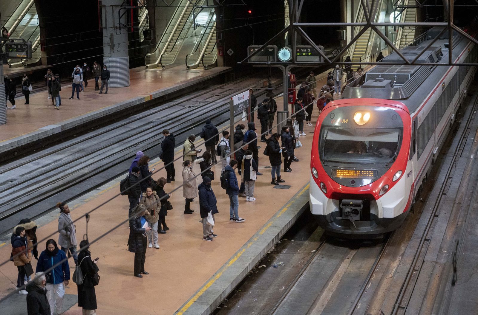 Varias personas esperan en el andén de Cercanías, en la estación Puerta de Atocha-Almudena Grandes