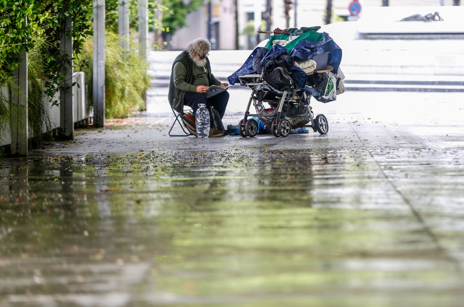 Una persona sin techo se refugia de la lluvia en Sevilla