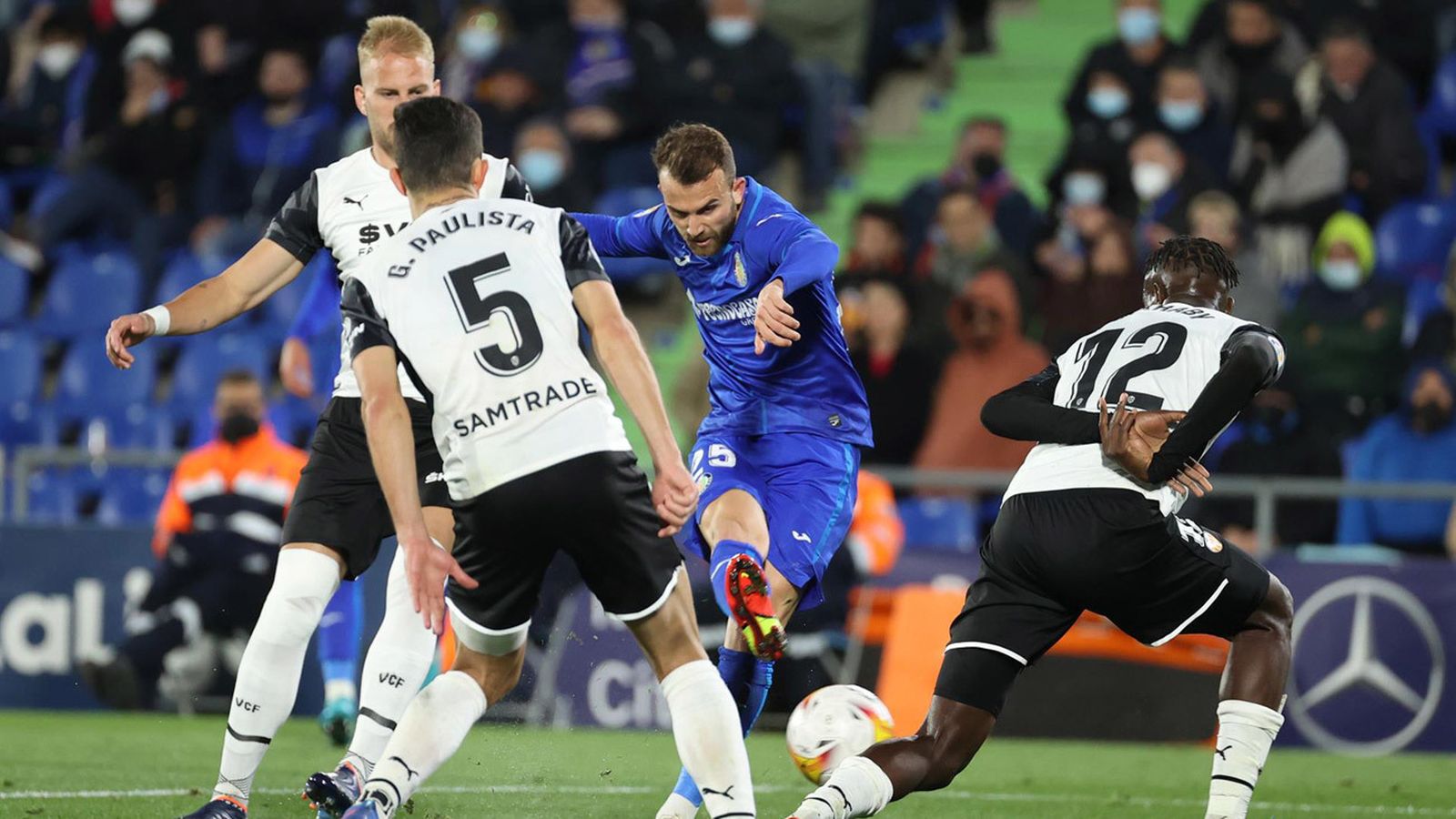 El delantero del Getafe, Borja Mayoral (2d), golpea el balón ante los defensores del Valencia durante el encuentro correspondiente a la jornada 28