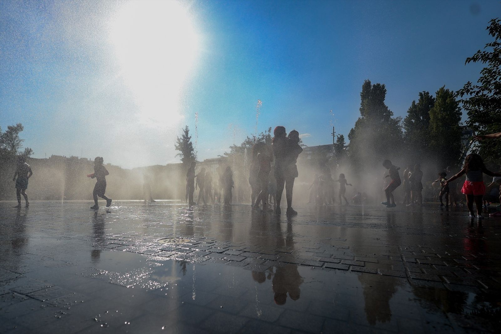 Varios niños se refrescan en una fuente en el parque Madrid Río,