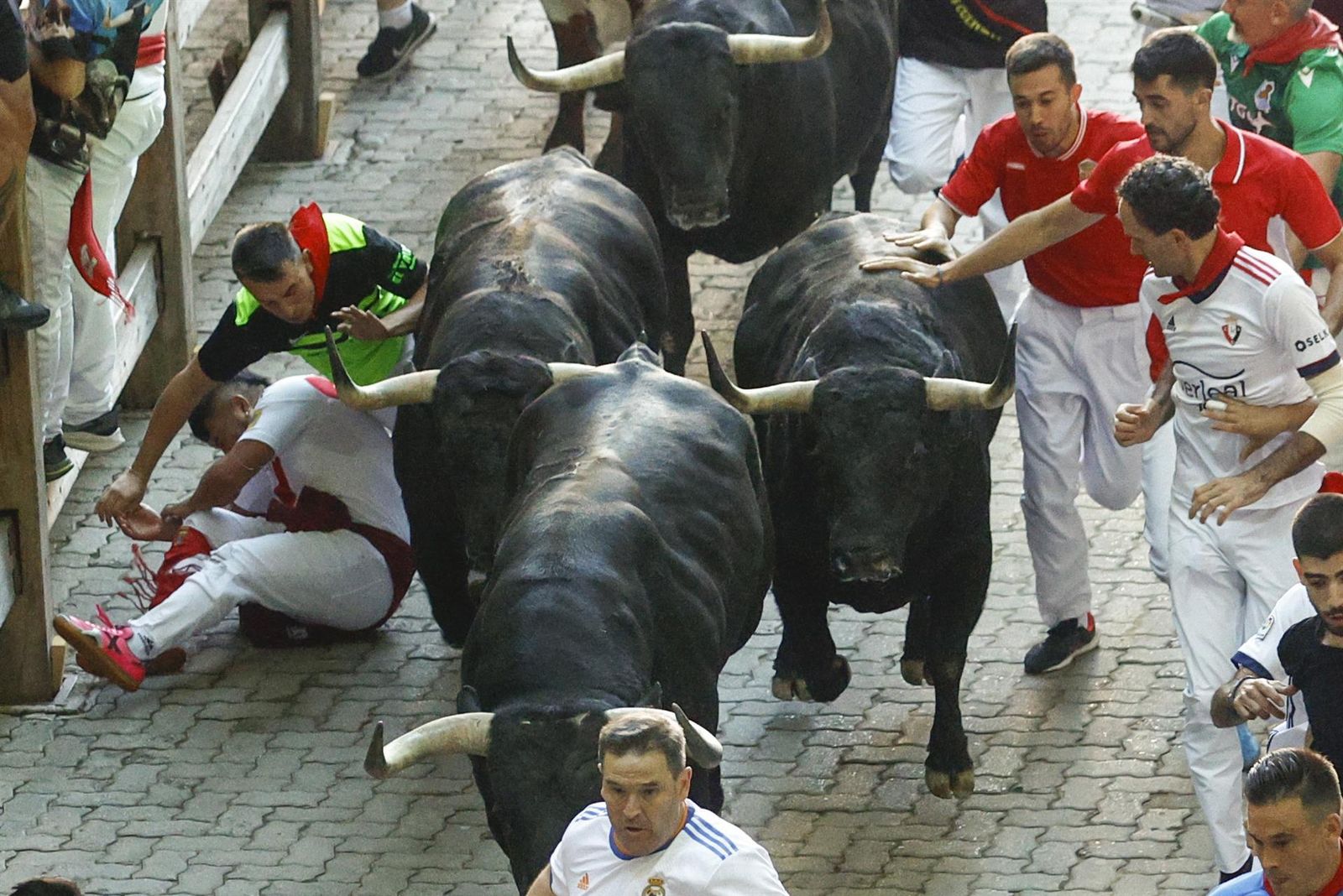Los mozos corren durante el séptimo encierro de los Sanfermines ante los toros de la ganadería de Victoriano del Río Cortés