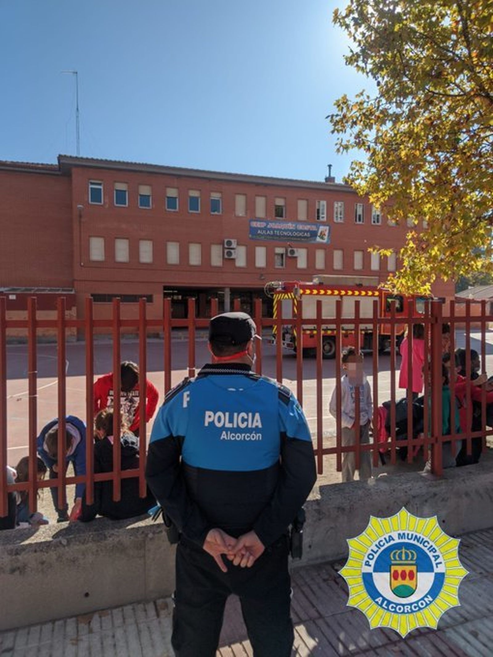 Un agente municipal de  Alcorcón frente a un colegio de la localidad