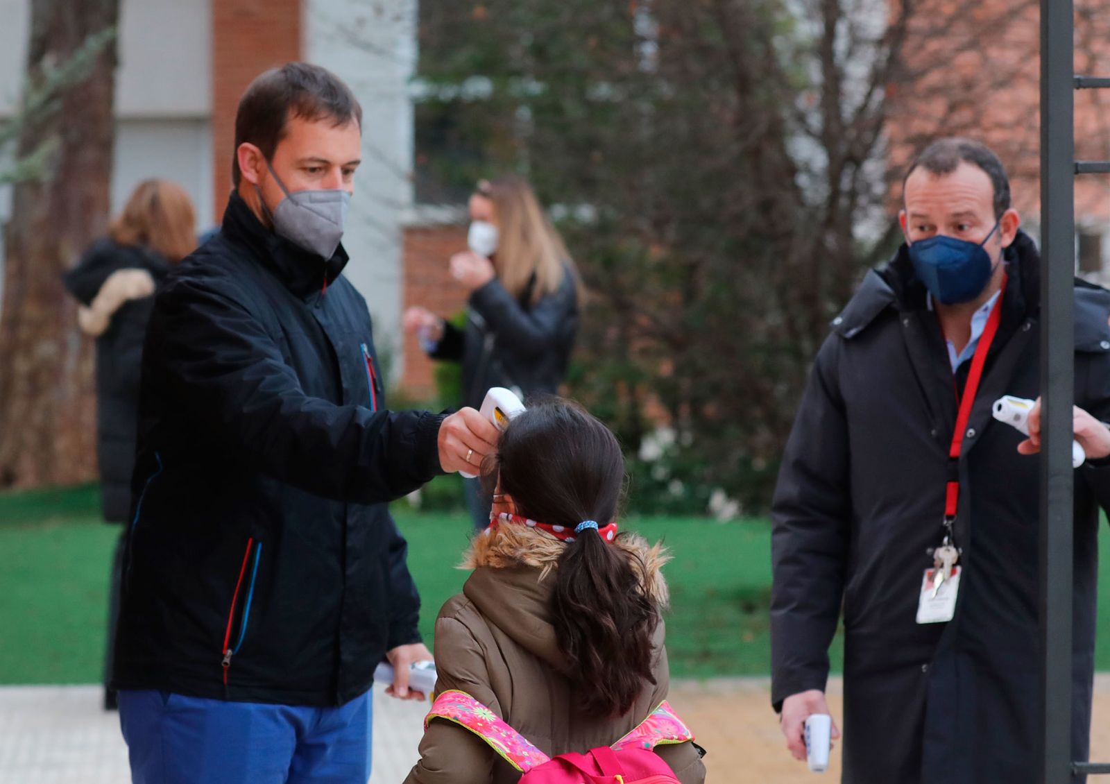 Un trabajador toma la temperatura a un niño a su llegada al primer día de clase presencial tras la Navidad