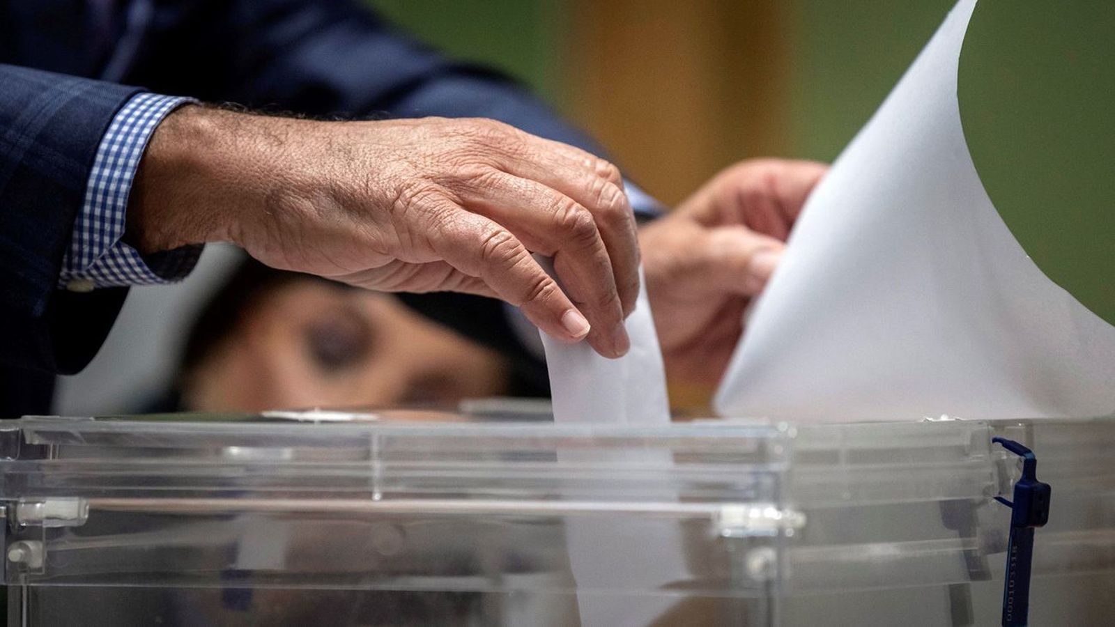 Un miembro de una mesa electoral introduce el voto en la urna