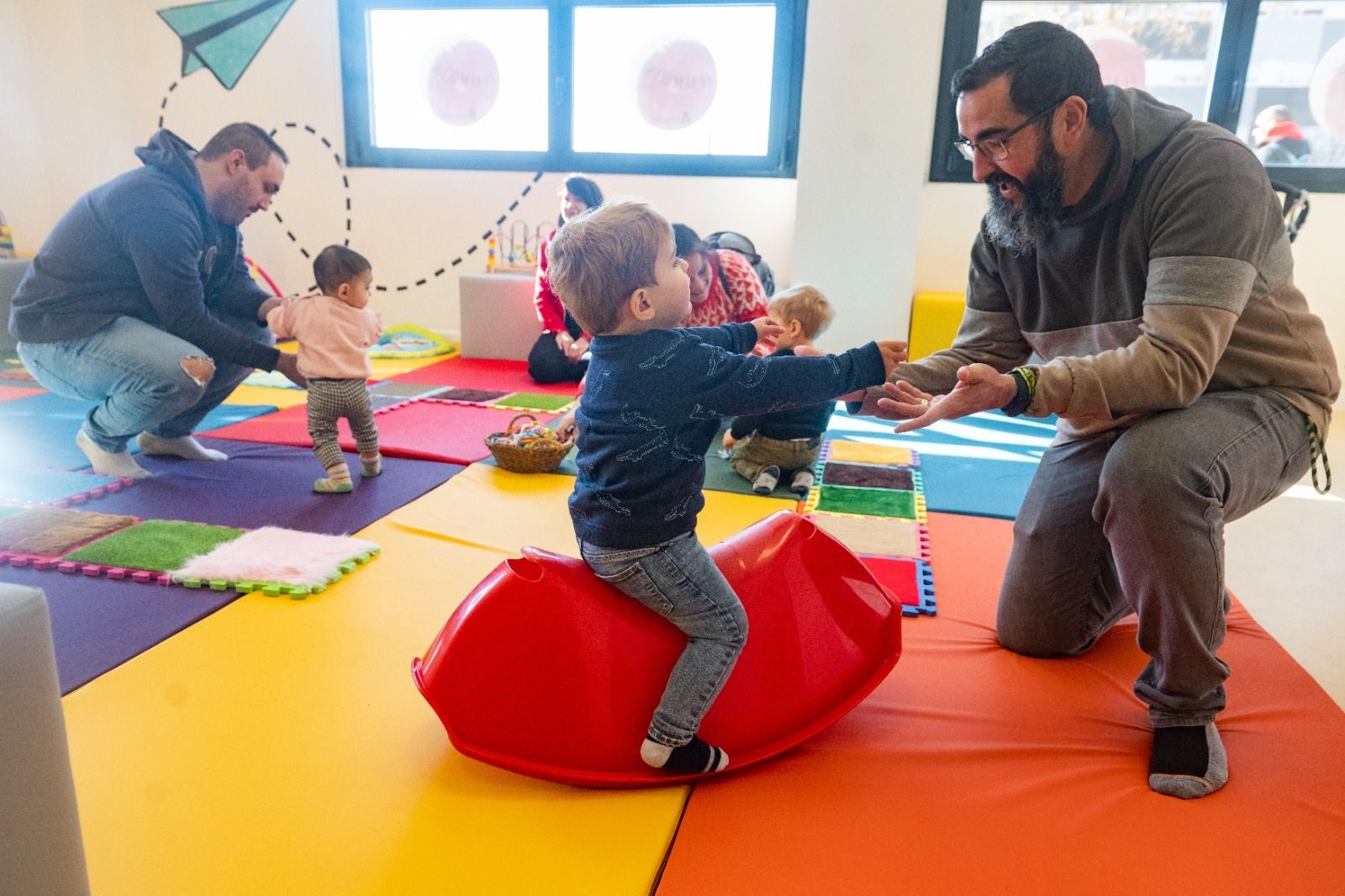 Padres jugando con sus hijos en el centro El Remolino de Espartales, en Alcalá de Henares