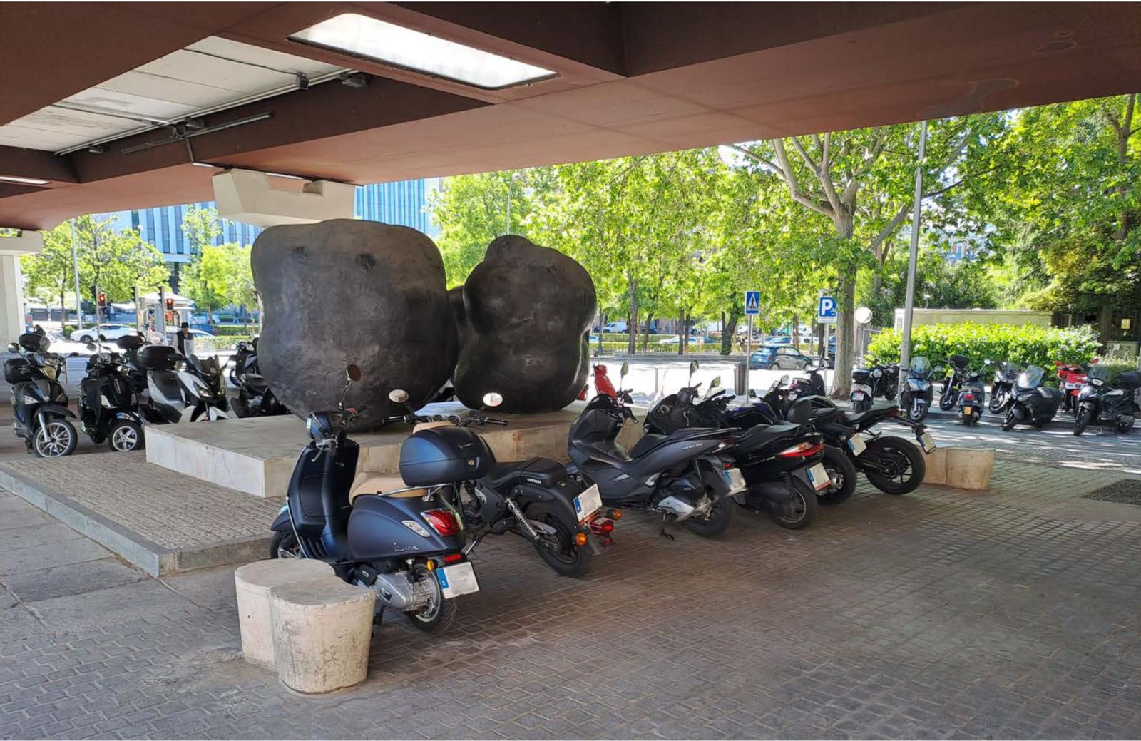Varias motos rodean una de las obras del Museo de Escultura al Aire Libre del Paseo de la Castellana
