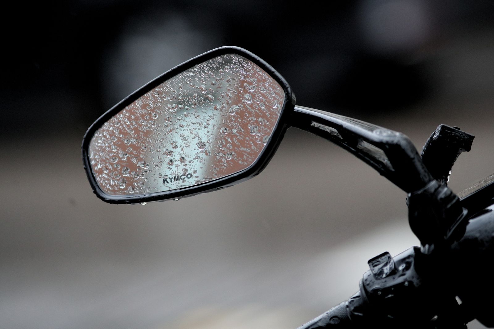 El espejo de una moto, mojado por agua de lluvia