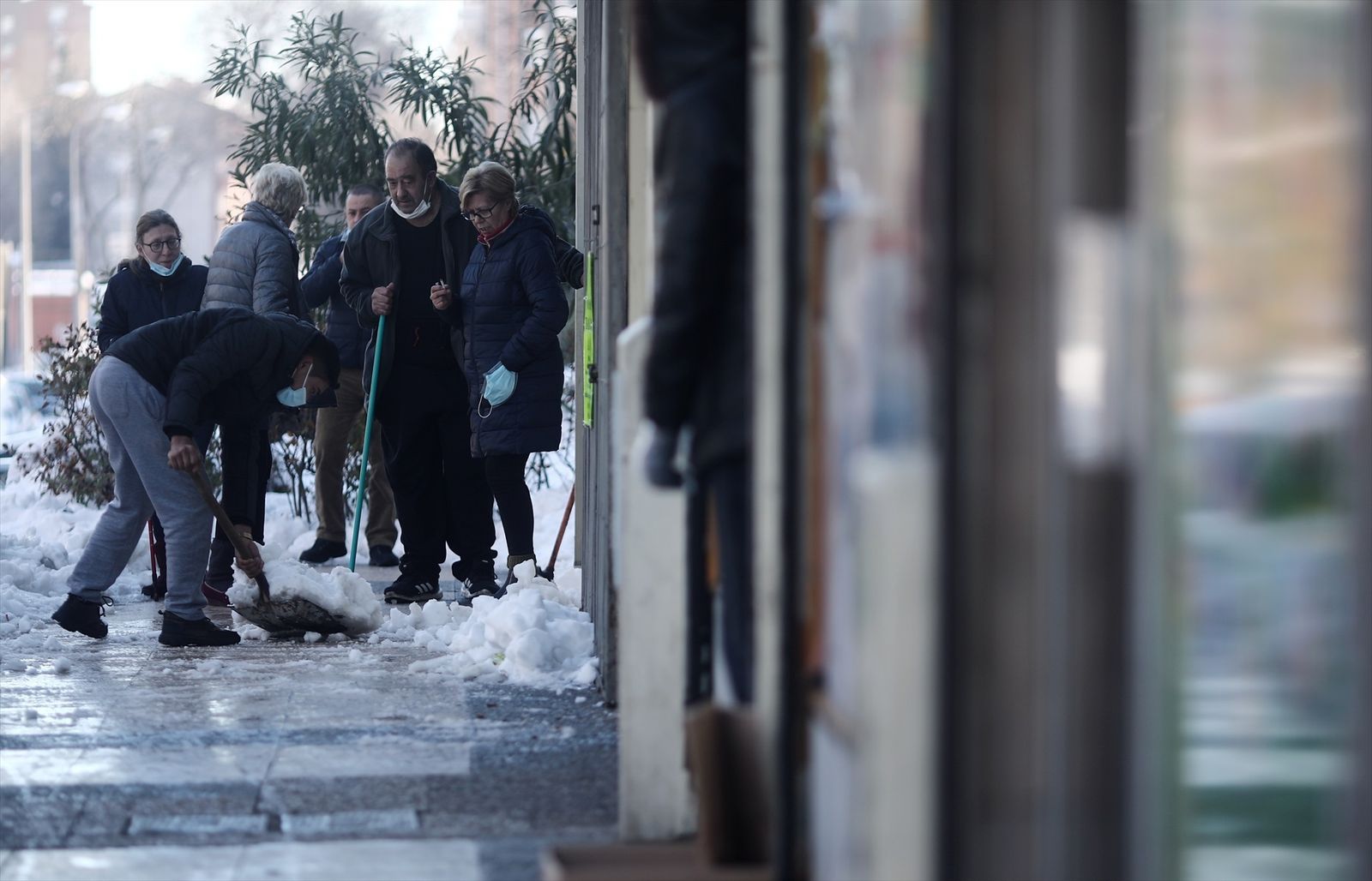 Vecinos del barrio de Pueblo Nuevo (Madrid) ayudan a quitar nieve y hielo de una calle durante la borrasca ‘Filomena’ de 2021