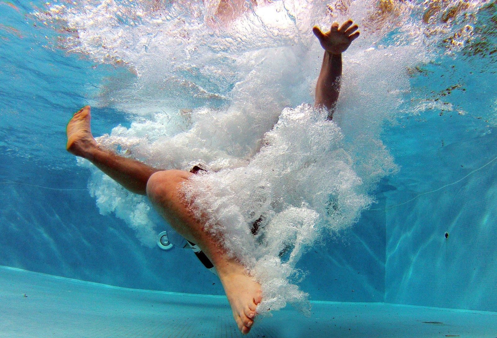 Foto de una persona sumergida en el agua de una piscina