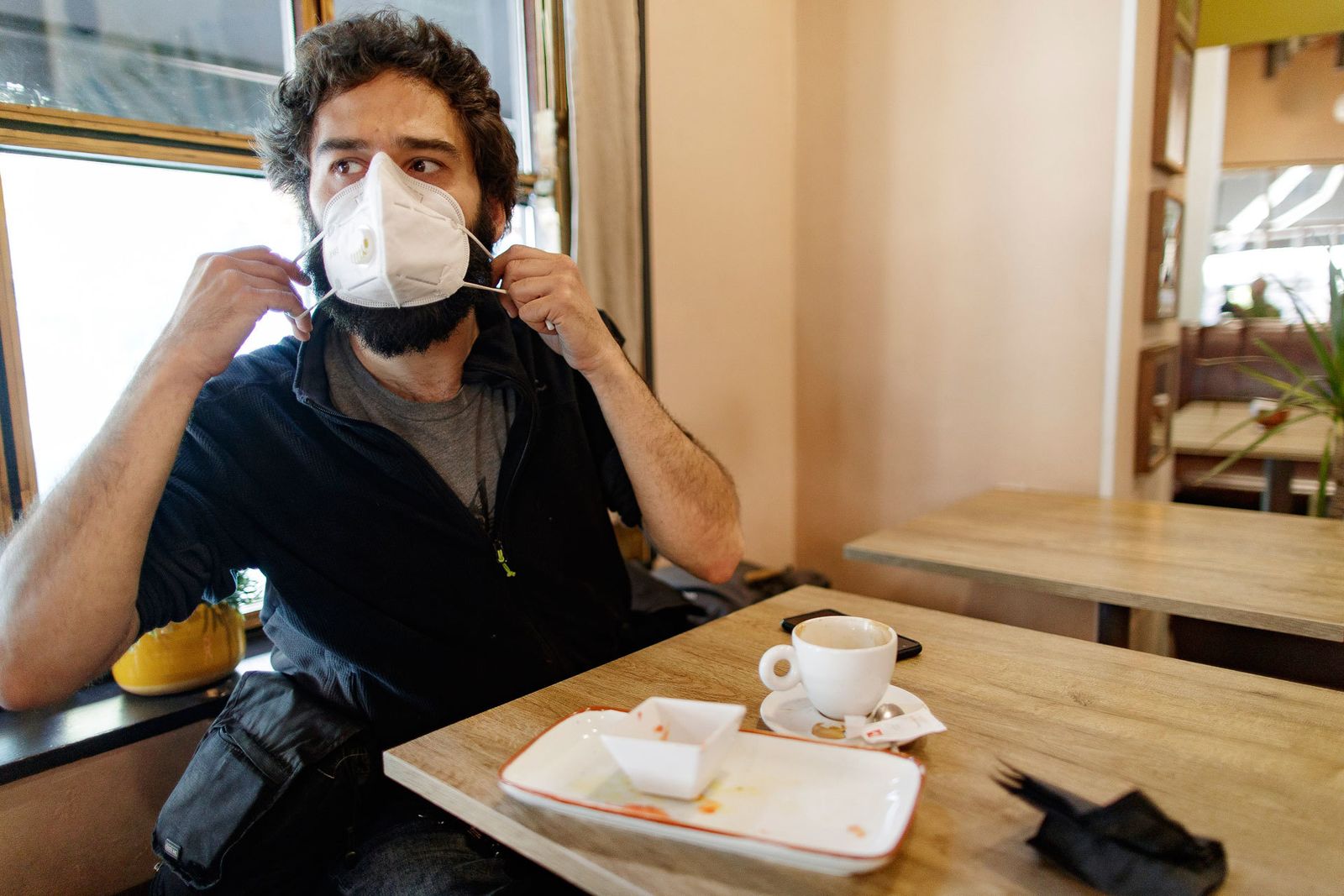 Un cliente se coloca la mascarilla en un restaurante