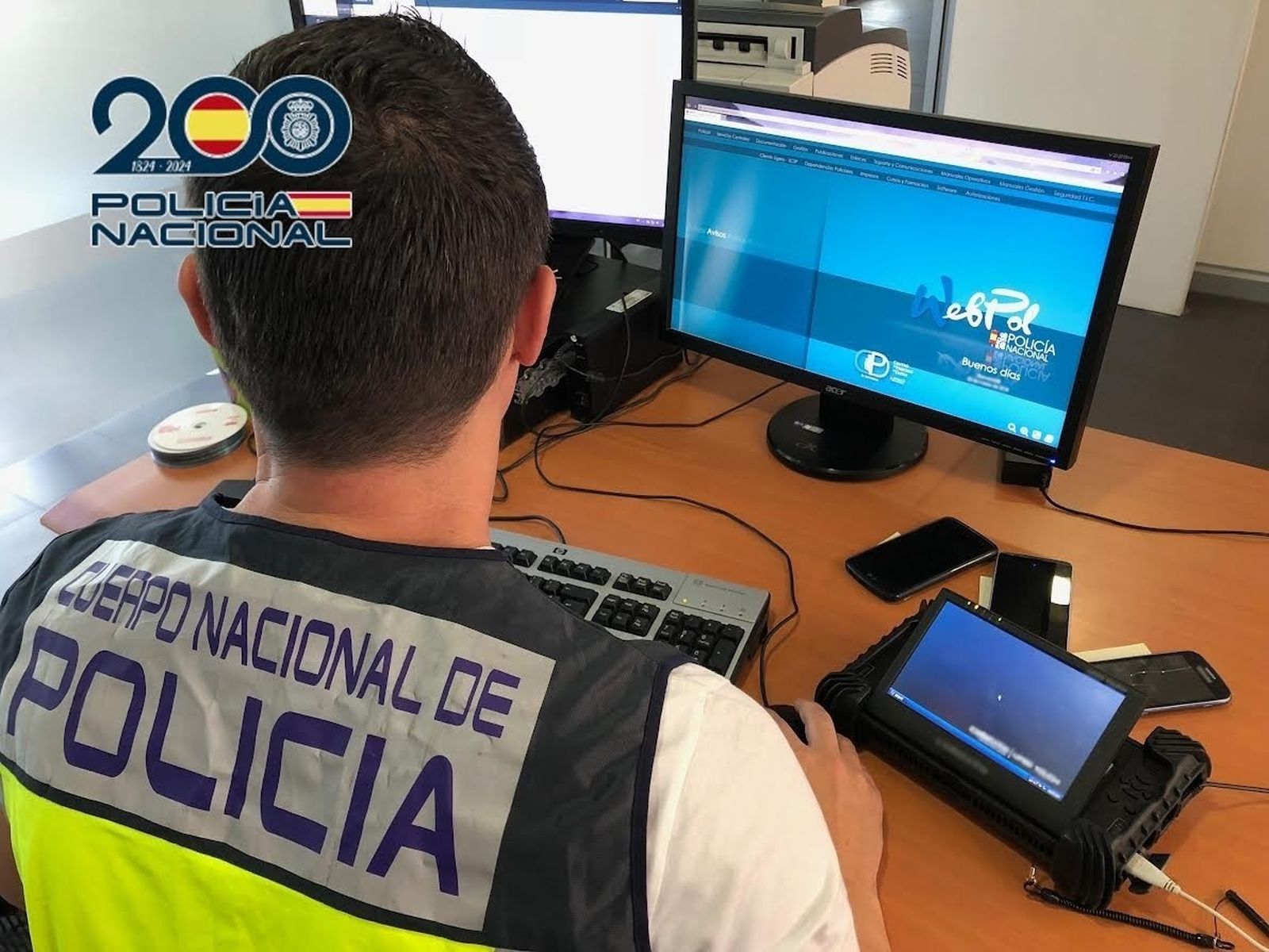 Imagen de un agente de Policía Nacional frente a un ordenador