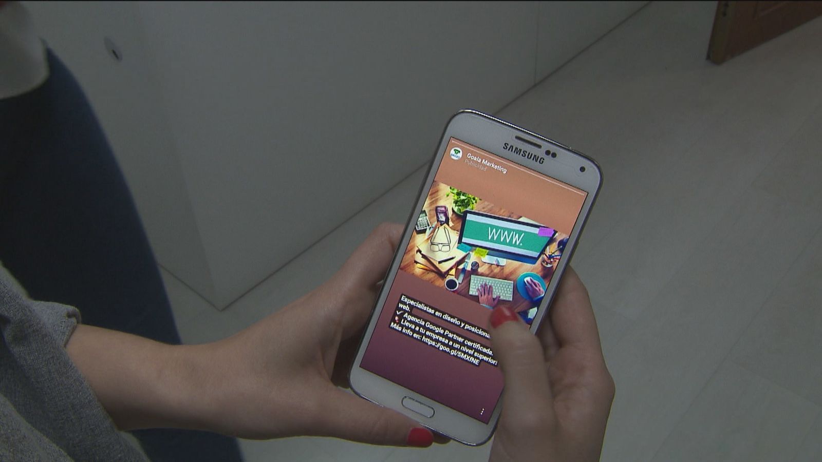 Una chica navega por internet con el móvil