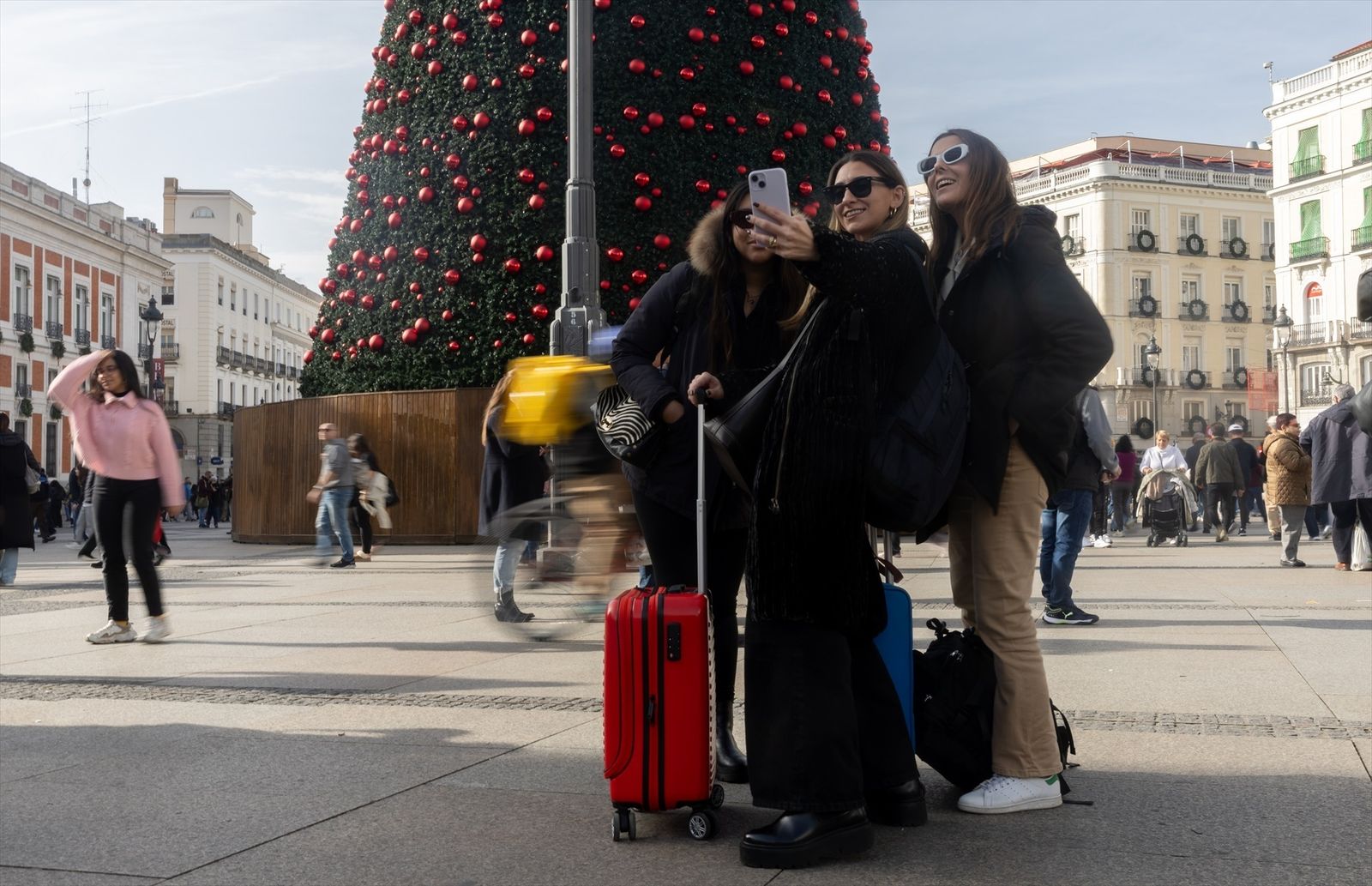 Varias turistas se hacen una foto junto al árbol de Navidad de la Puerta del Sol