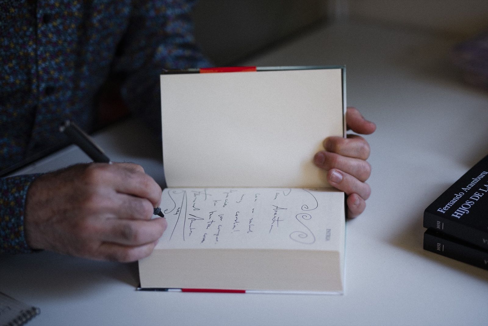 El escritor Fernando Aramburu firma un libro durante la 83ª edición de la Feria del Libro de Madrid, en el Parque del Retiro, a 1 de junio de 2024,