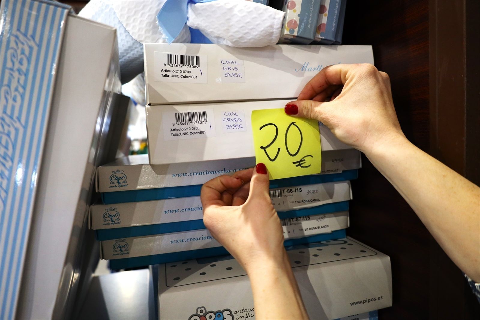Una mujer pone una etiqueta de 20 euros en uno de sus productos