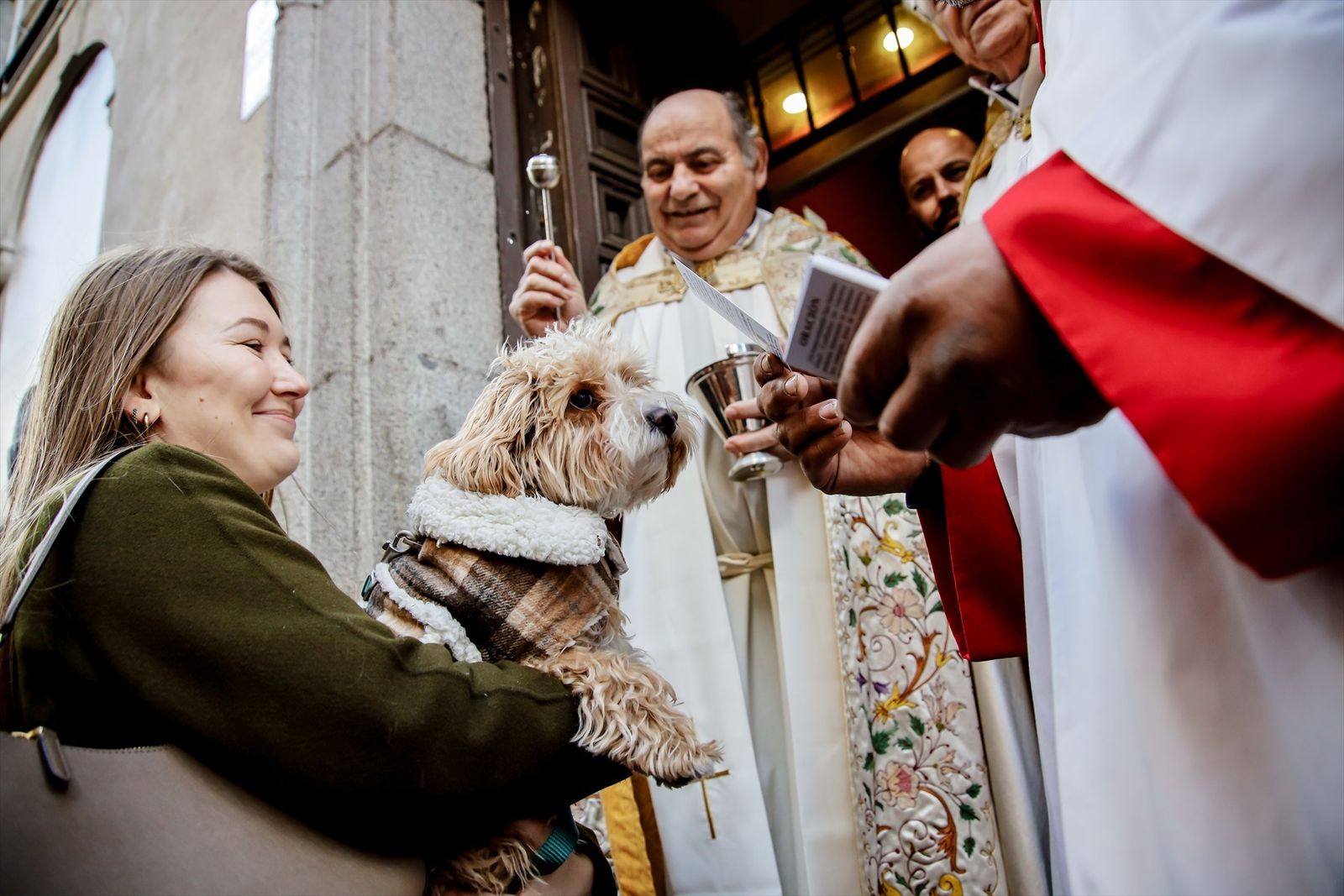 Un sacerdote bendice a un perro en la iglesia de San Antón de Madrid