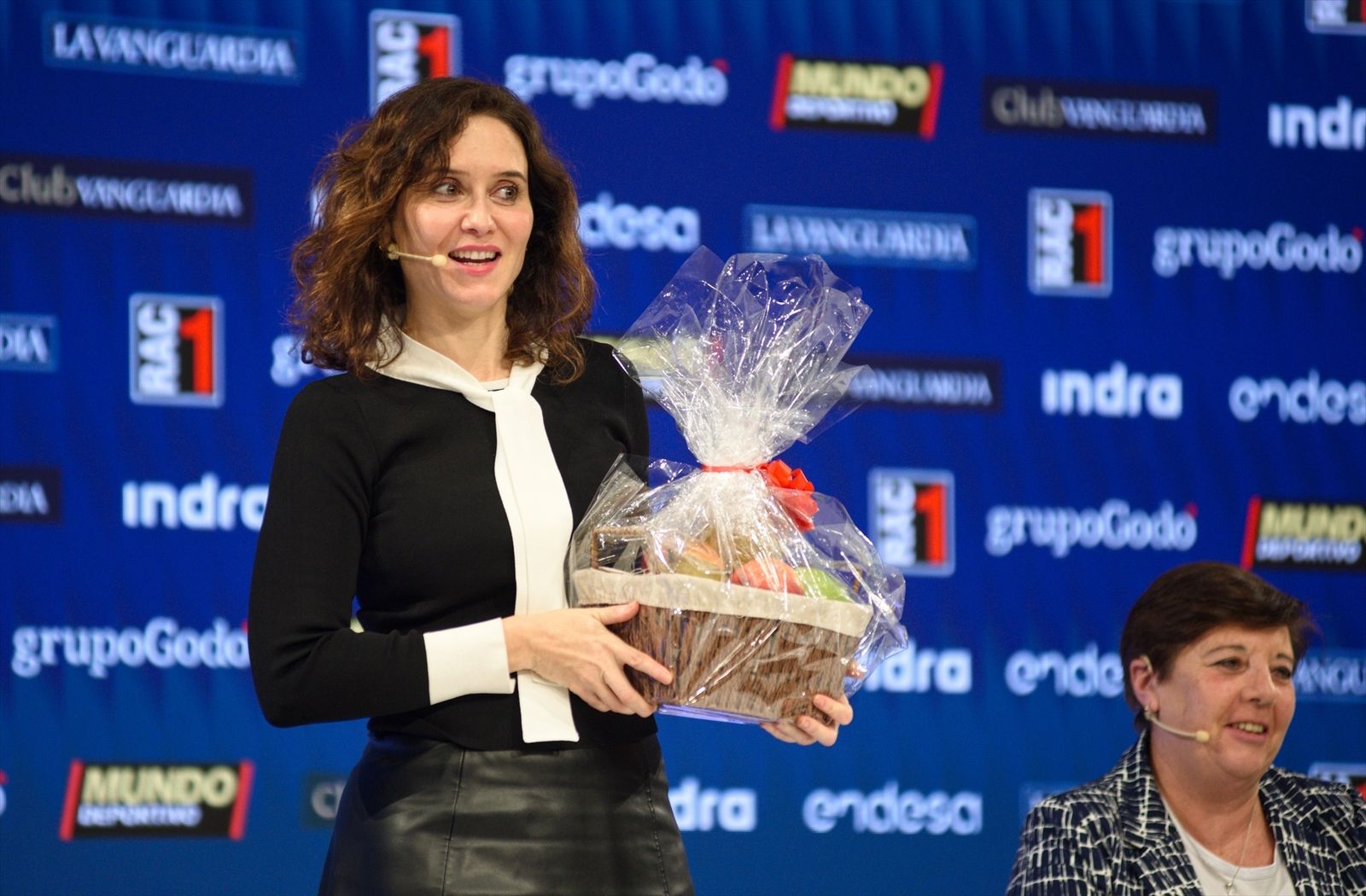 La presidenta de la Comunidad de Madrid Isabel Díaz Ayuso recibe una cesta de frutas,