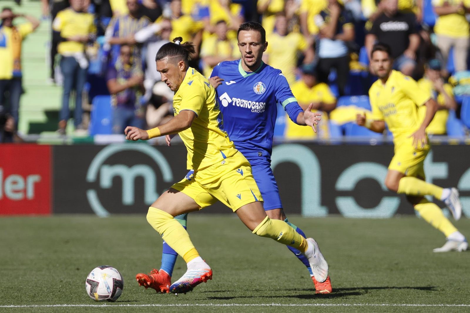El centrocampista esloveno del Getafe FC, Nemanja Maksimovic lucha por el balón con el defensa uruguayo Luis Espino del Cádiz FC