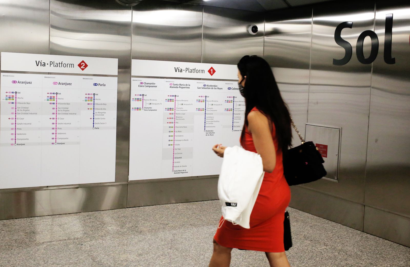 Una madrileña observa un cartel de información de Cercanías Madrid