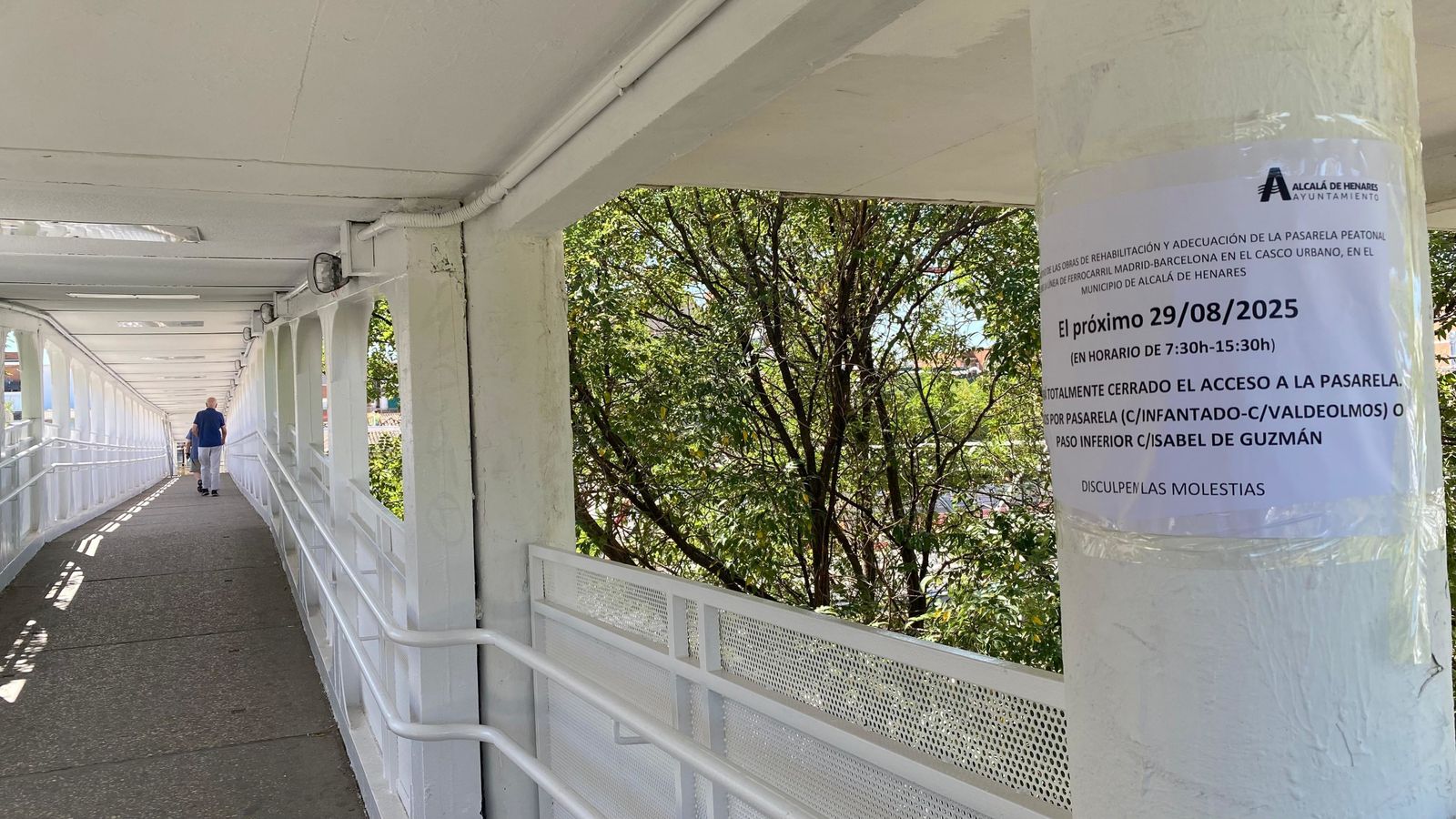 Aviso en la pasarela peatonal sobre la vías del tren en Alcalá de Henares