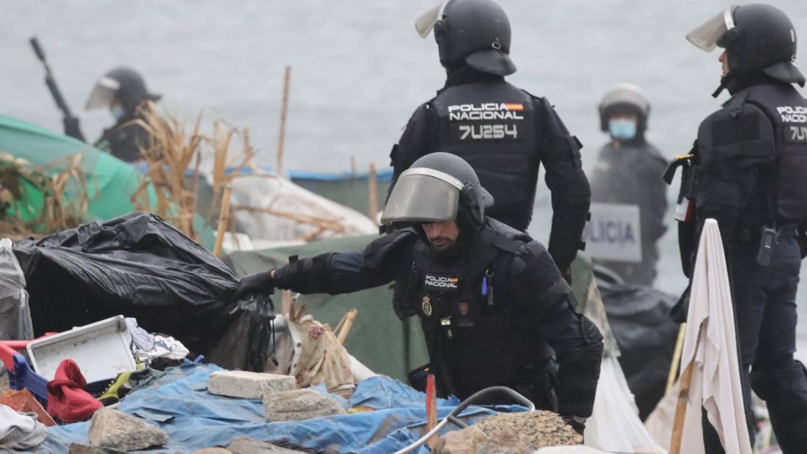 Dispositivo de la Policía Nacional para levantar el asentamiento de la playa del Trampolín de Ceuta