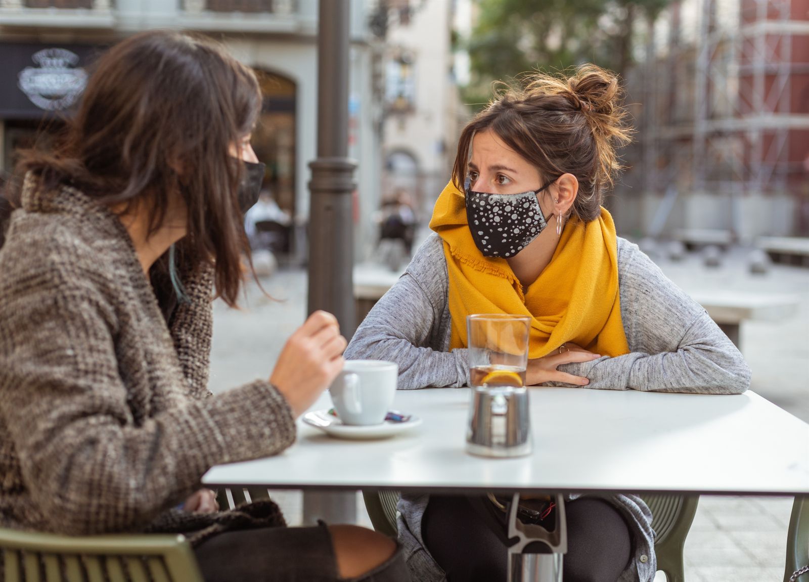Dos jóvenes toman un café en una terraza de Madrid