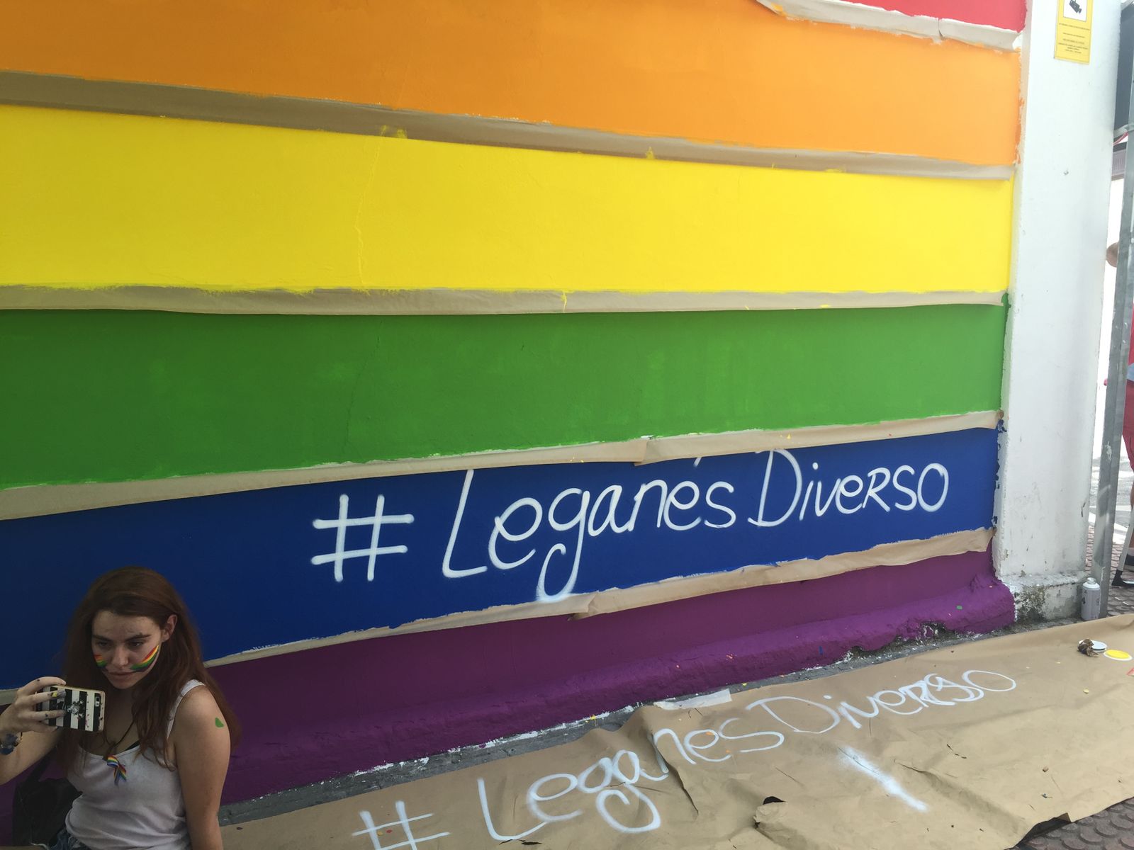 Una joven se hace un selfie junto a un mural a favor de la diversidad en Leganés